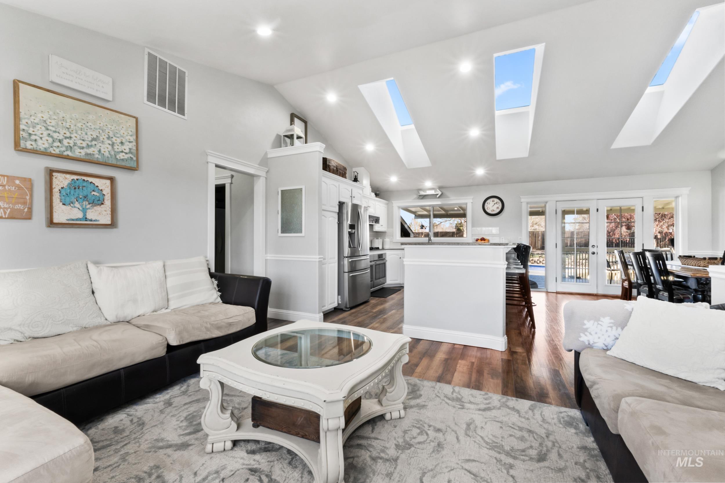Living area featuring french doors, recessed lighting, dark wood-type flooring, and high vaulted ceiling