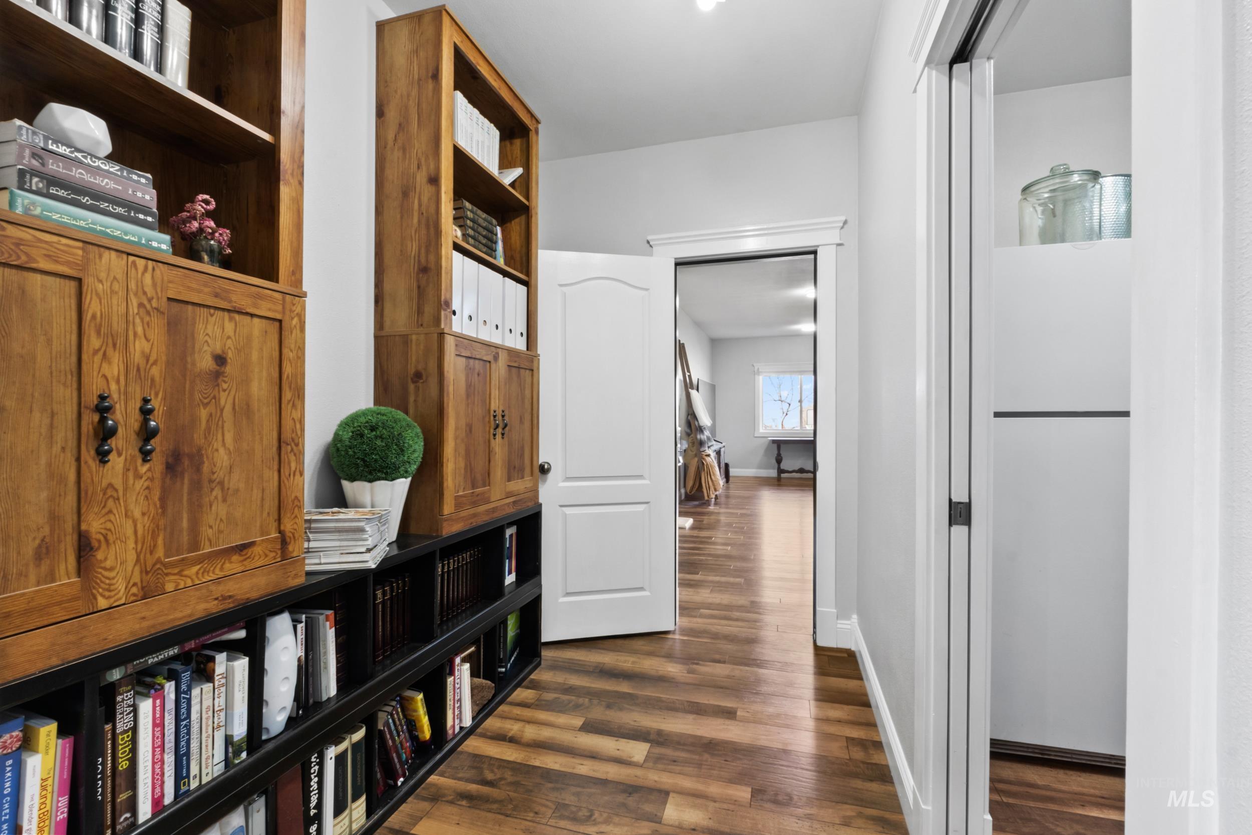 Hall with dark wood-type flooring and baseboards