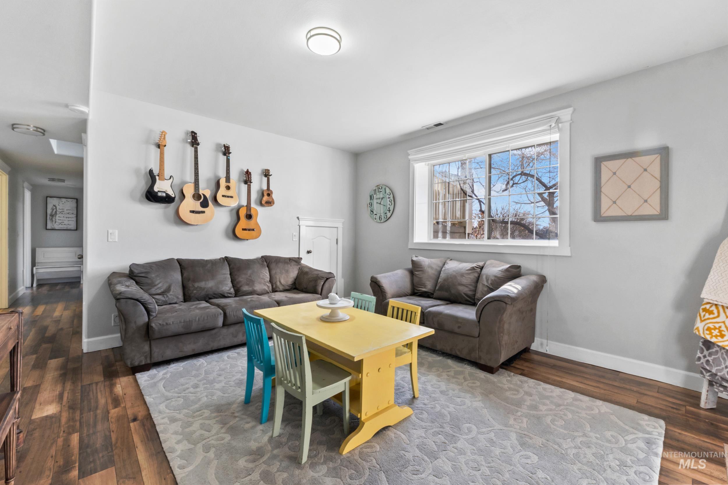 Living area with dark wood-style floors and baseboards
