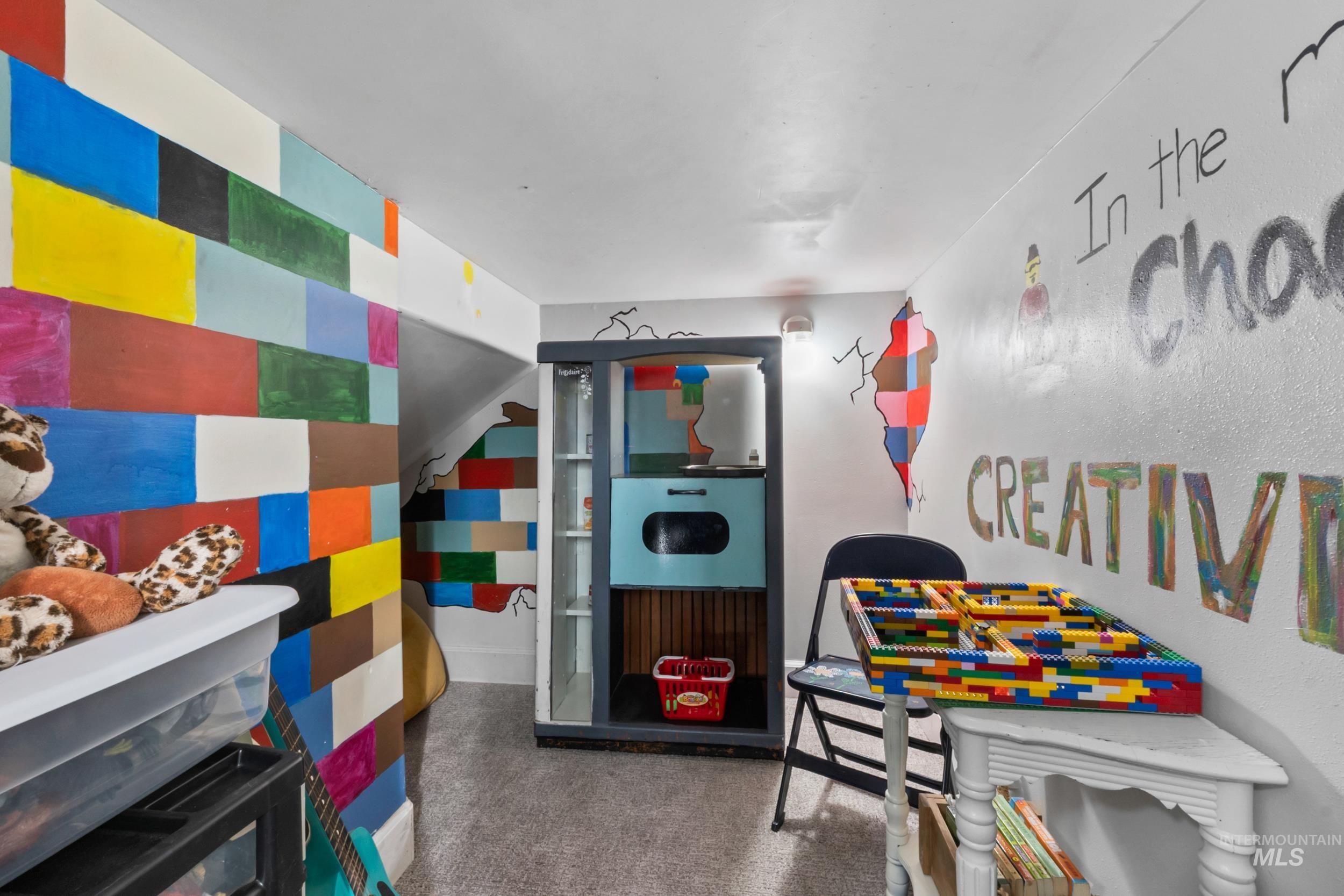 Playroom with dark carpet and an accent wall