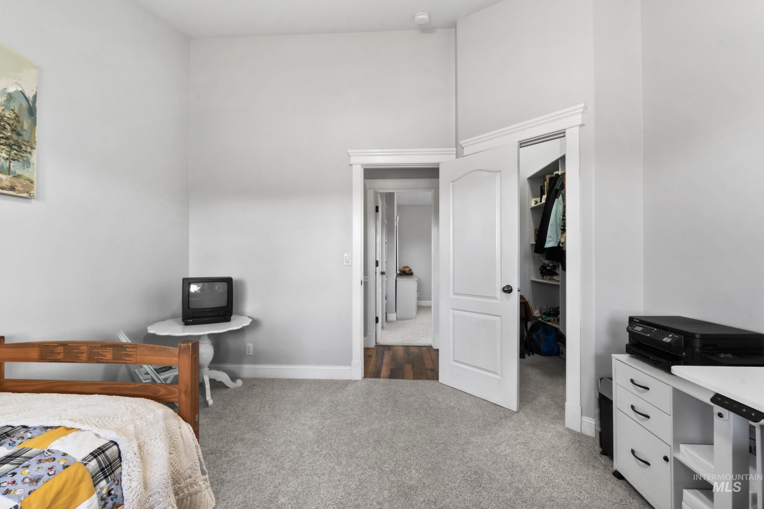 Bedroom featuring light colored carpet and a high ceiling