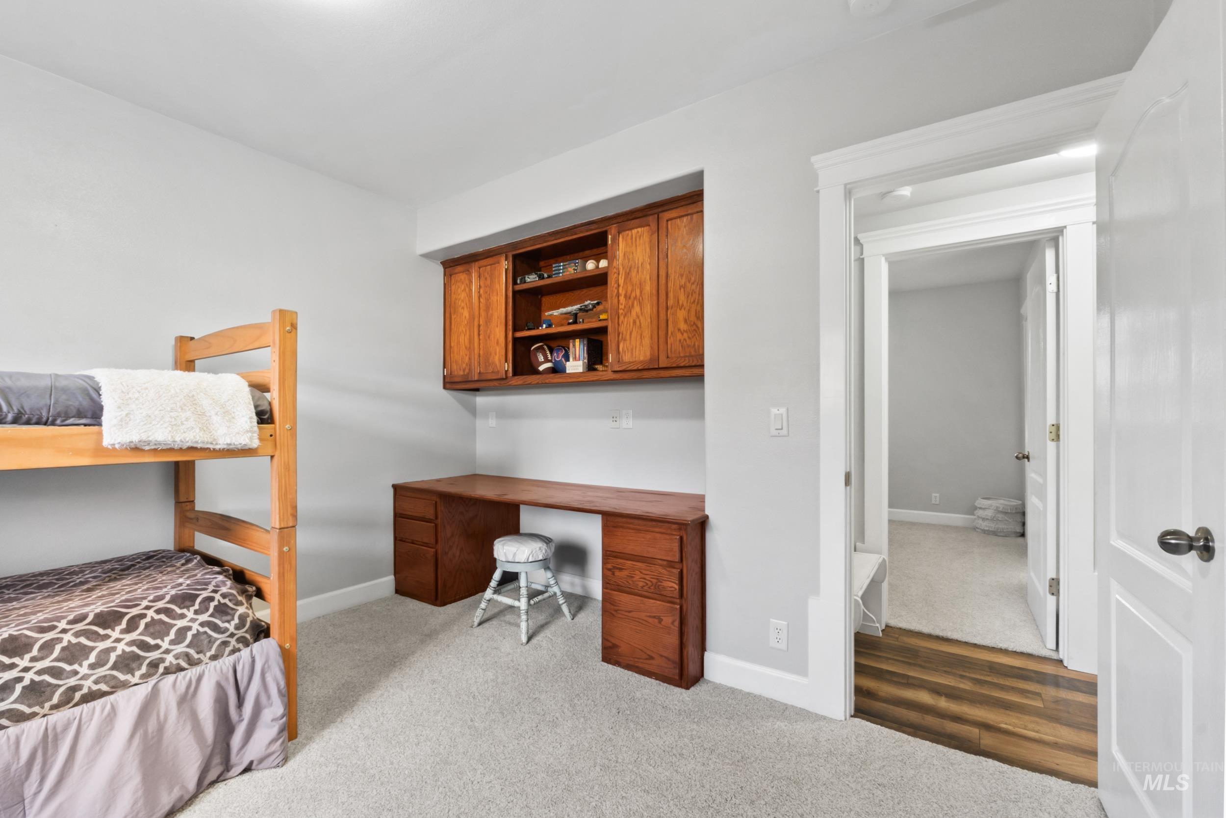 Bedroom with light carpet and built in study area