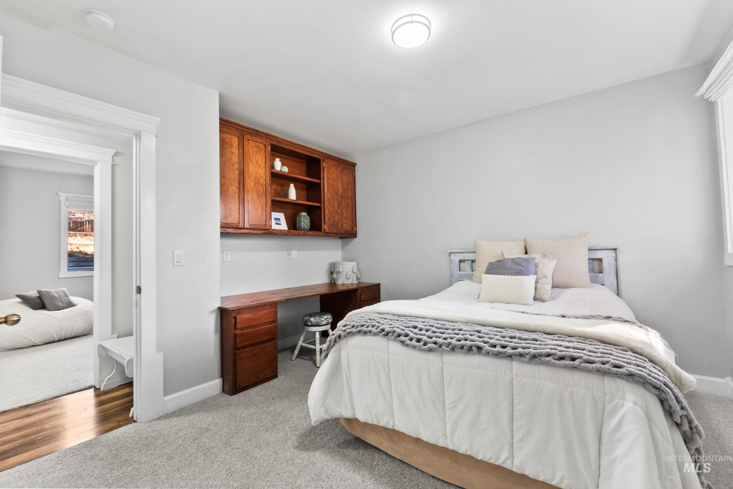 Bedroom with built in study area and light carpet