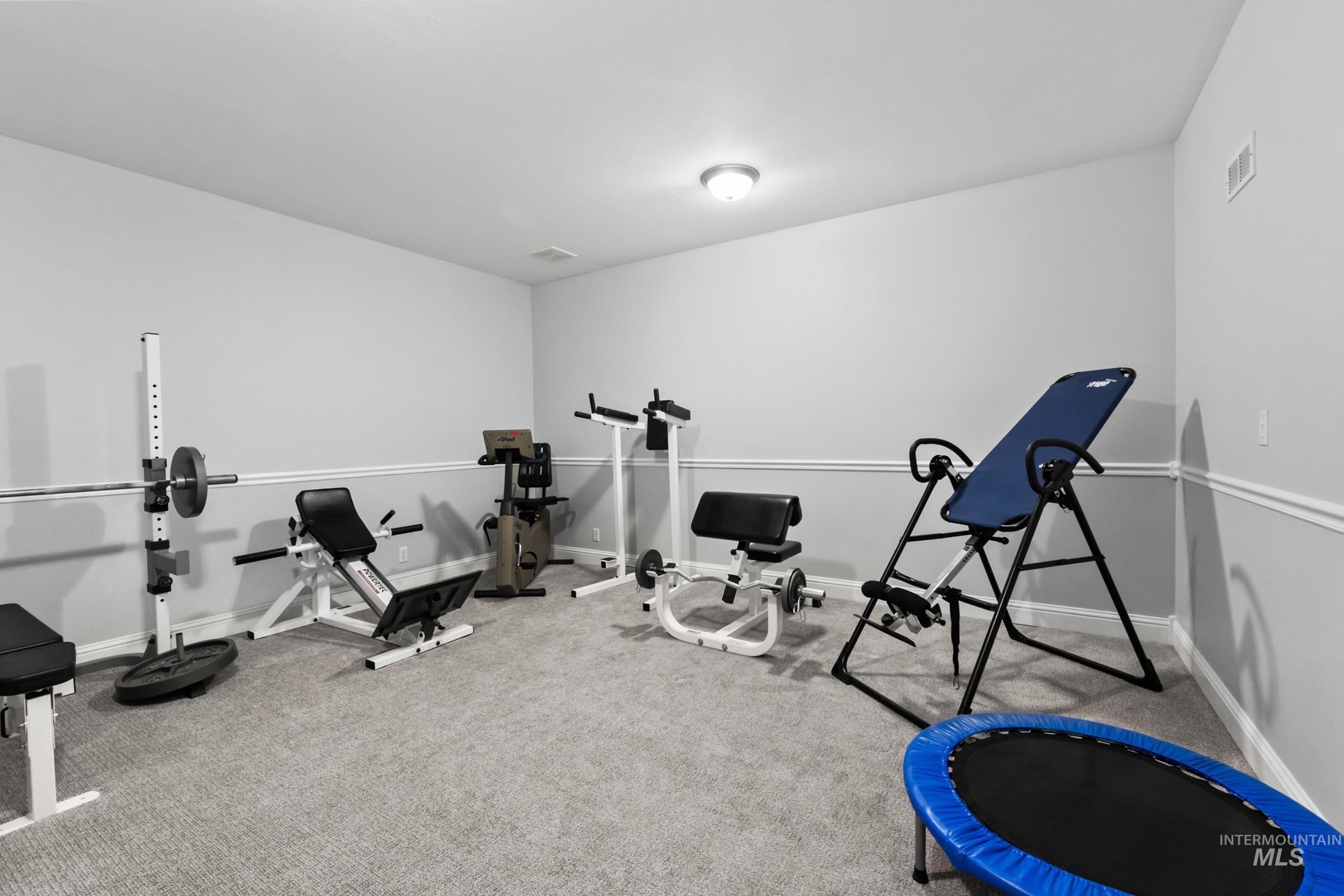 Exercise area featuring carpet floors and baseboards