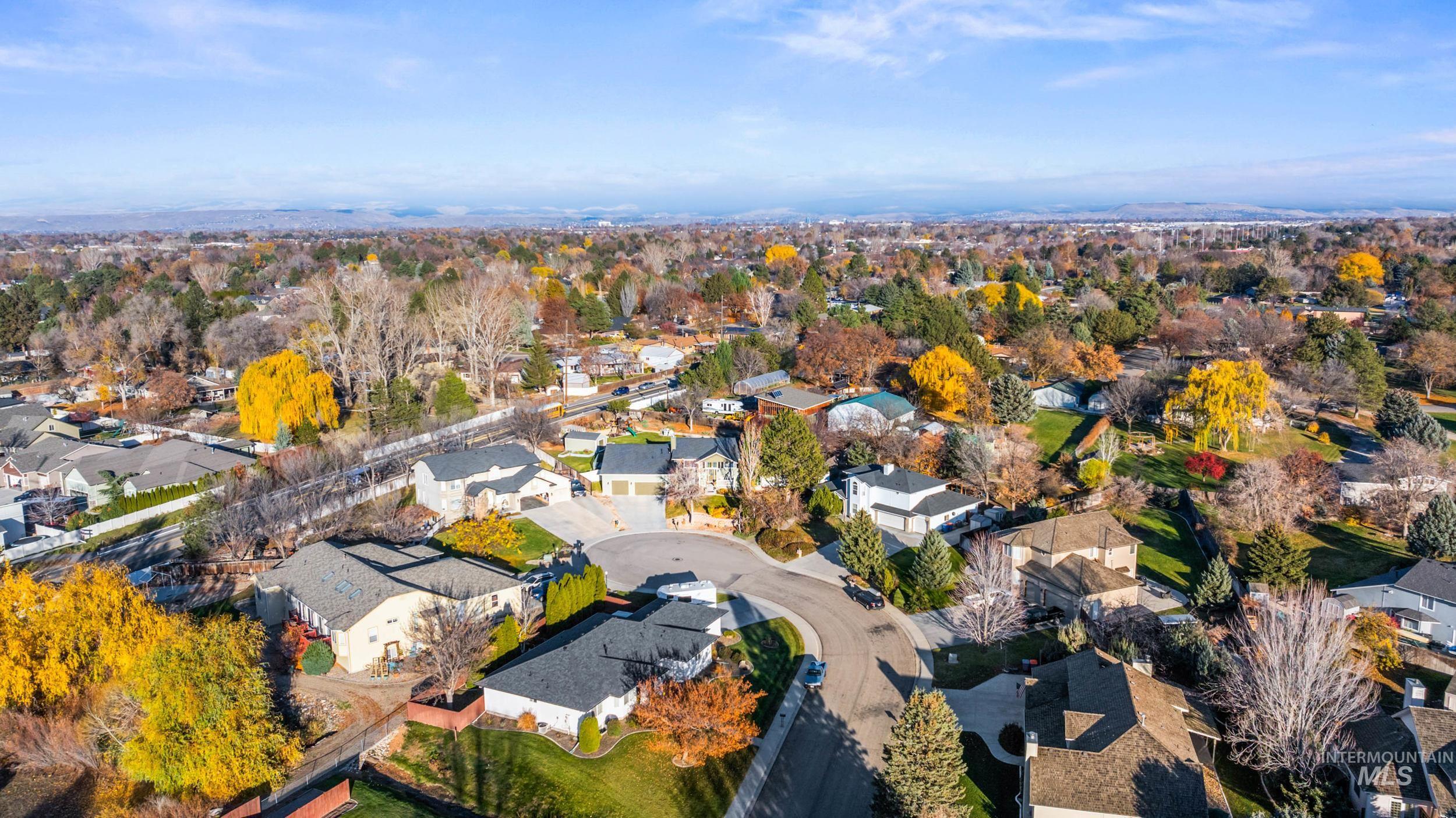 Aerial view of property and surrounding area featuring nearby suburban area