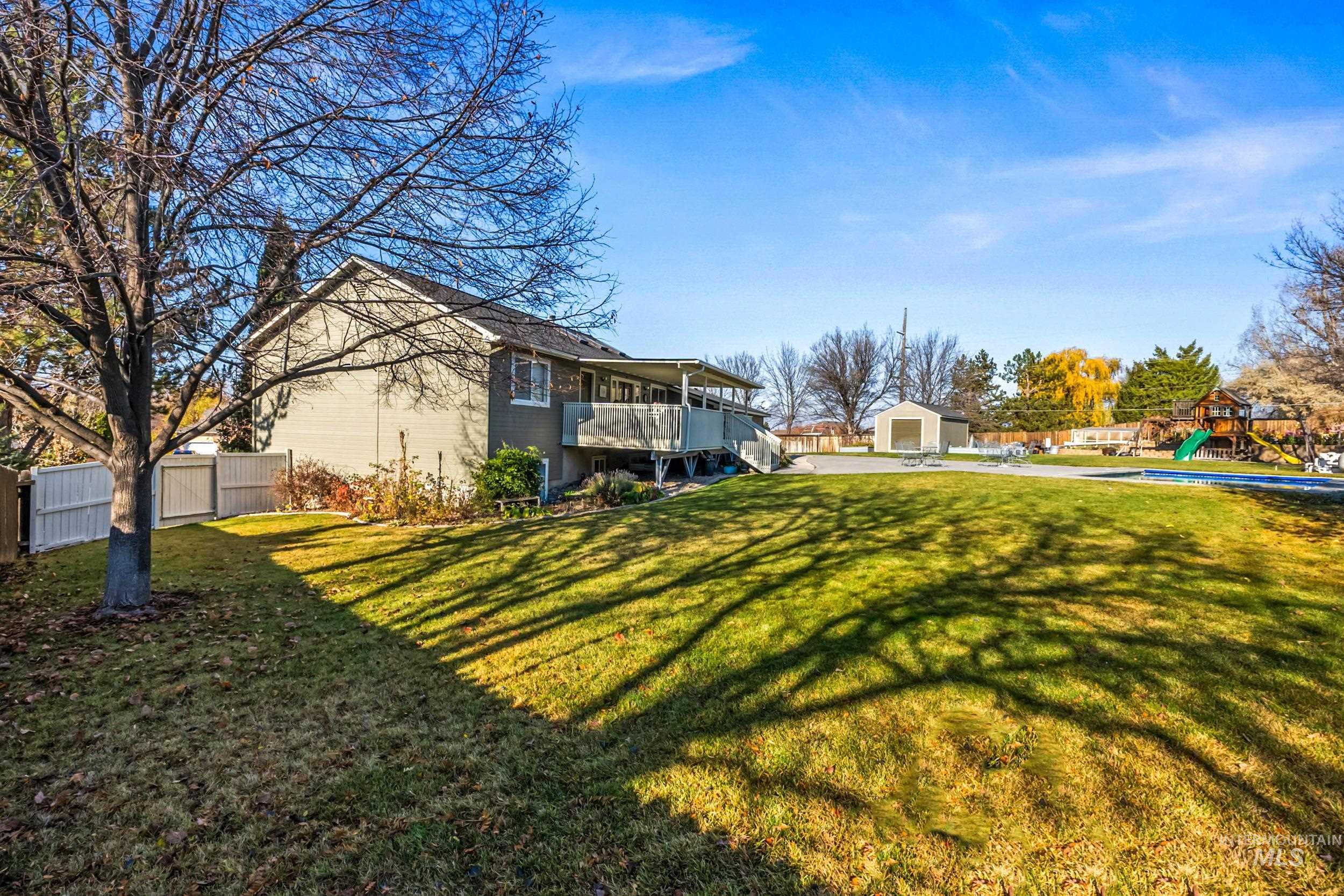View of yard with a playground, a balcony, and an outdoor structure