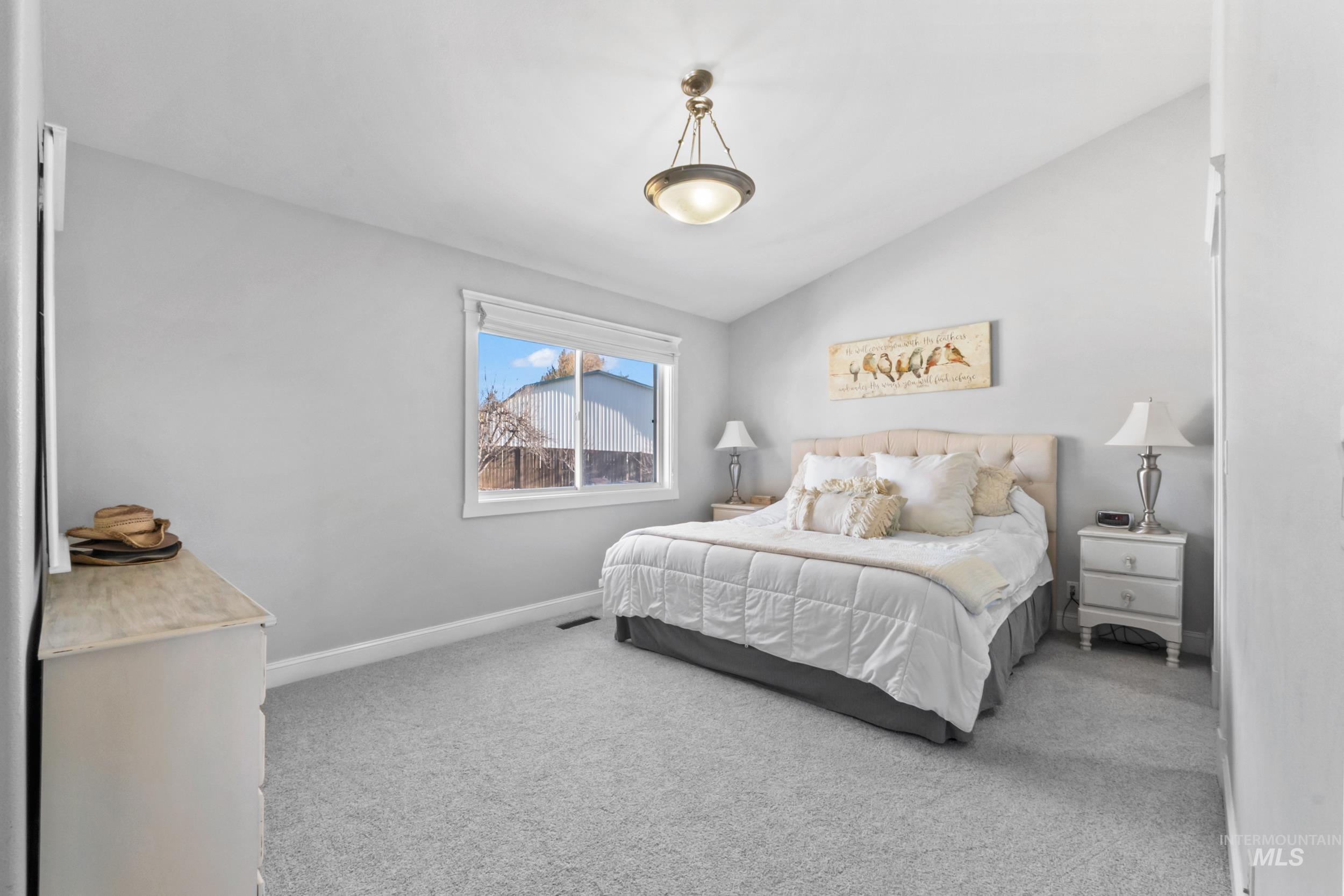 Bedroom featuring carpet floors and lofted ceiling