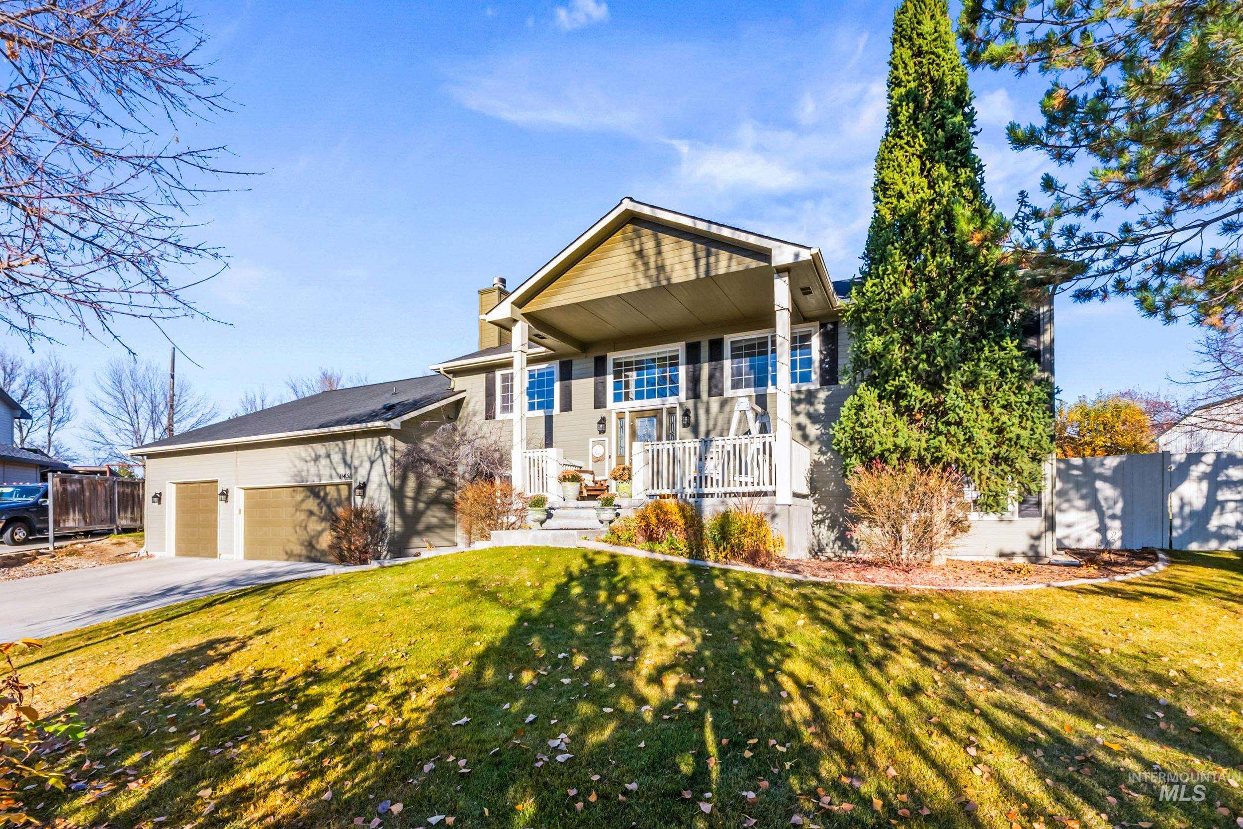 View of front of house with driveway, a chimney, and a garage