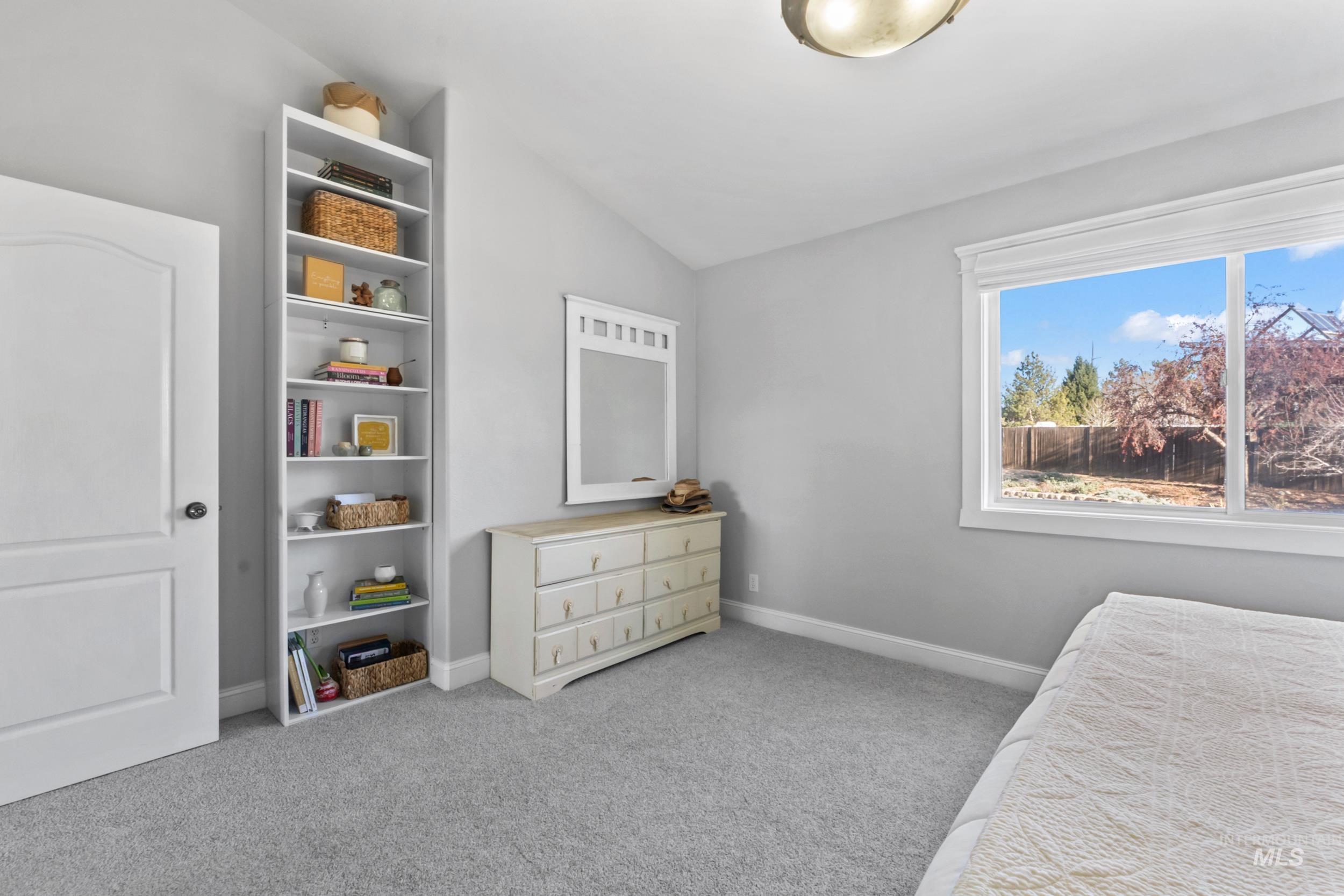 Bedroom featuring lofted ceiling and light carpet