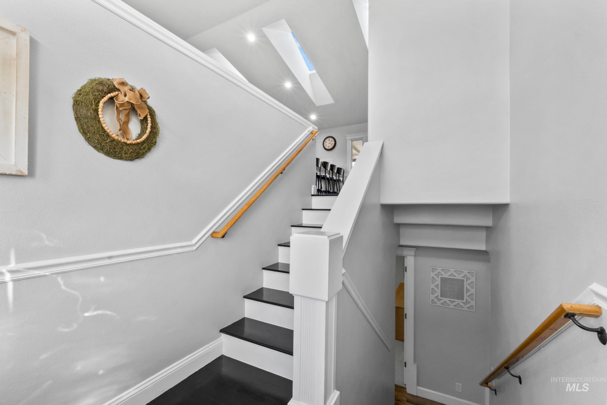 Staircase featuring a skylight and baseboards