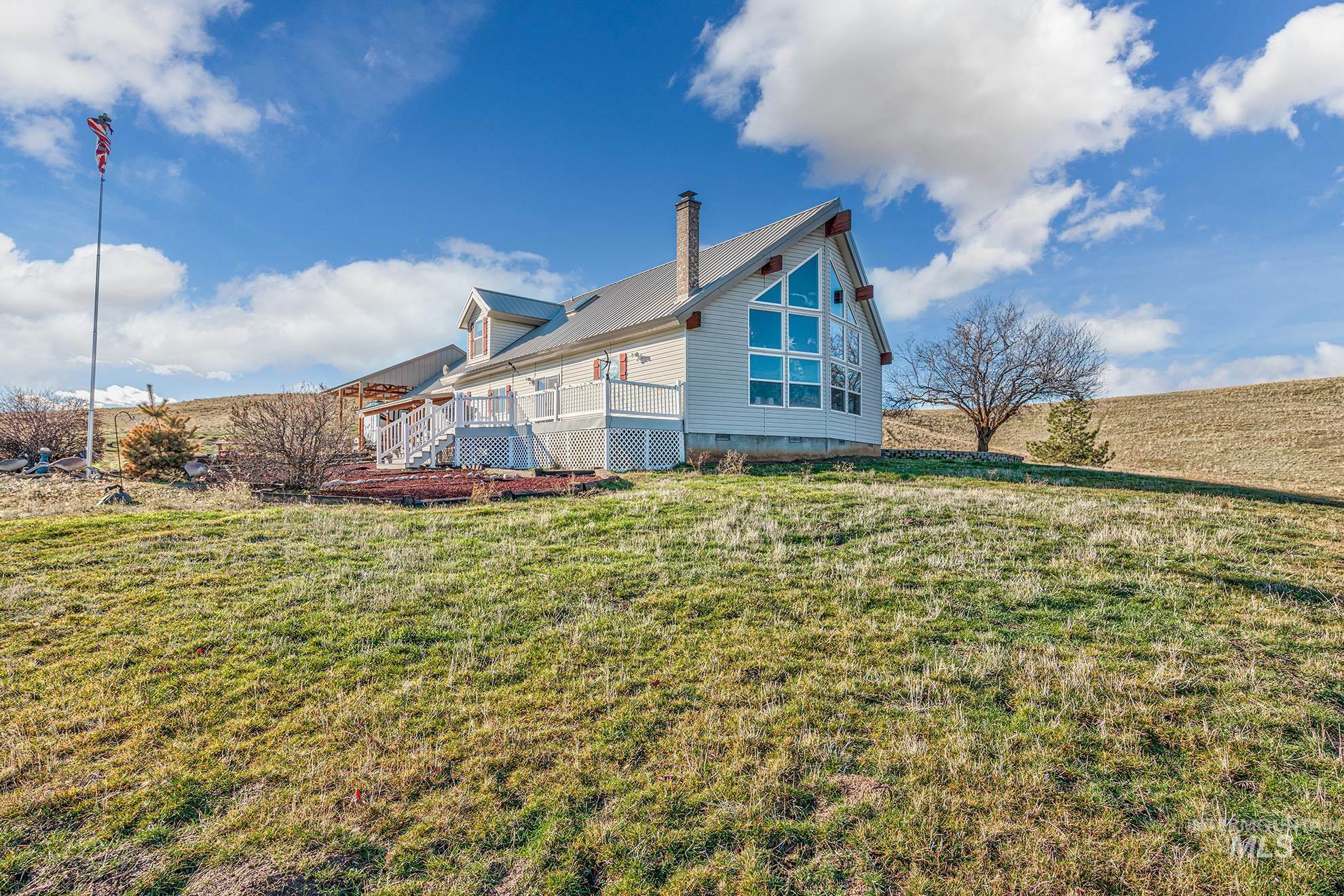 View of side of home with crawl space, a lawn, a deck, and a metal roof