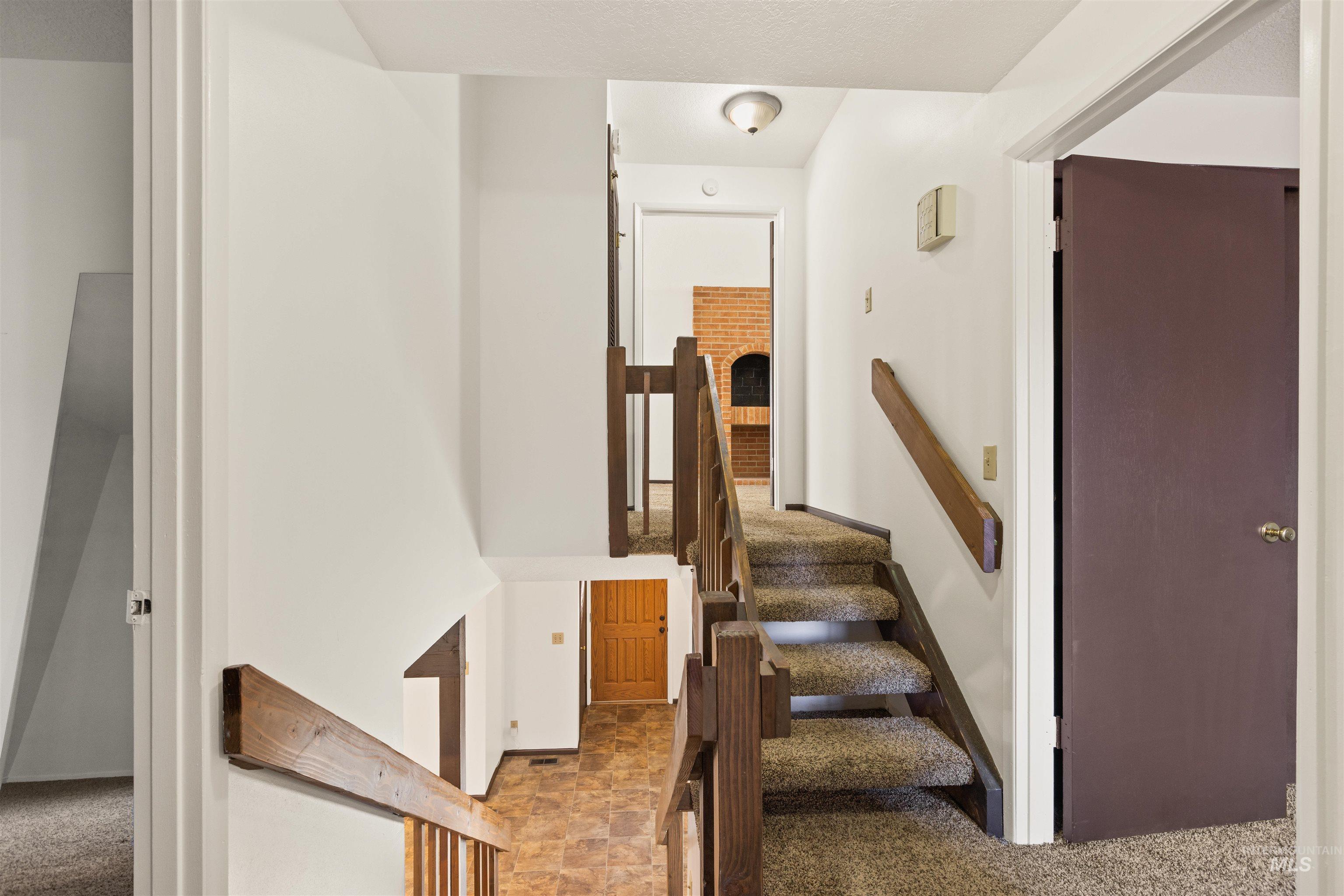 Stairway featuring carpet flooring and stone finish floors