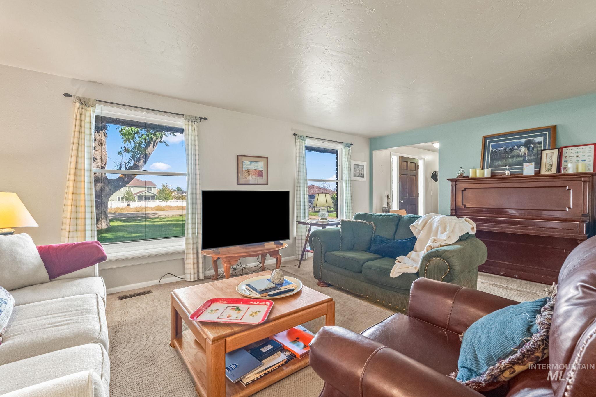 Carpeted living room with a textured ceiling and baseboards