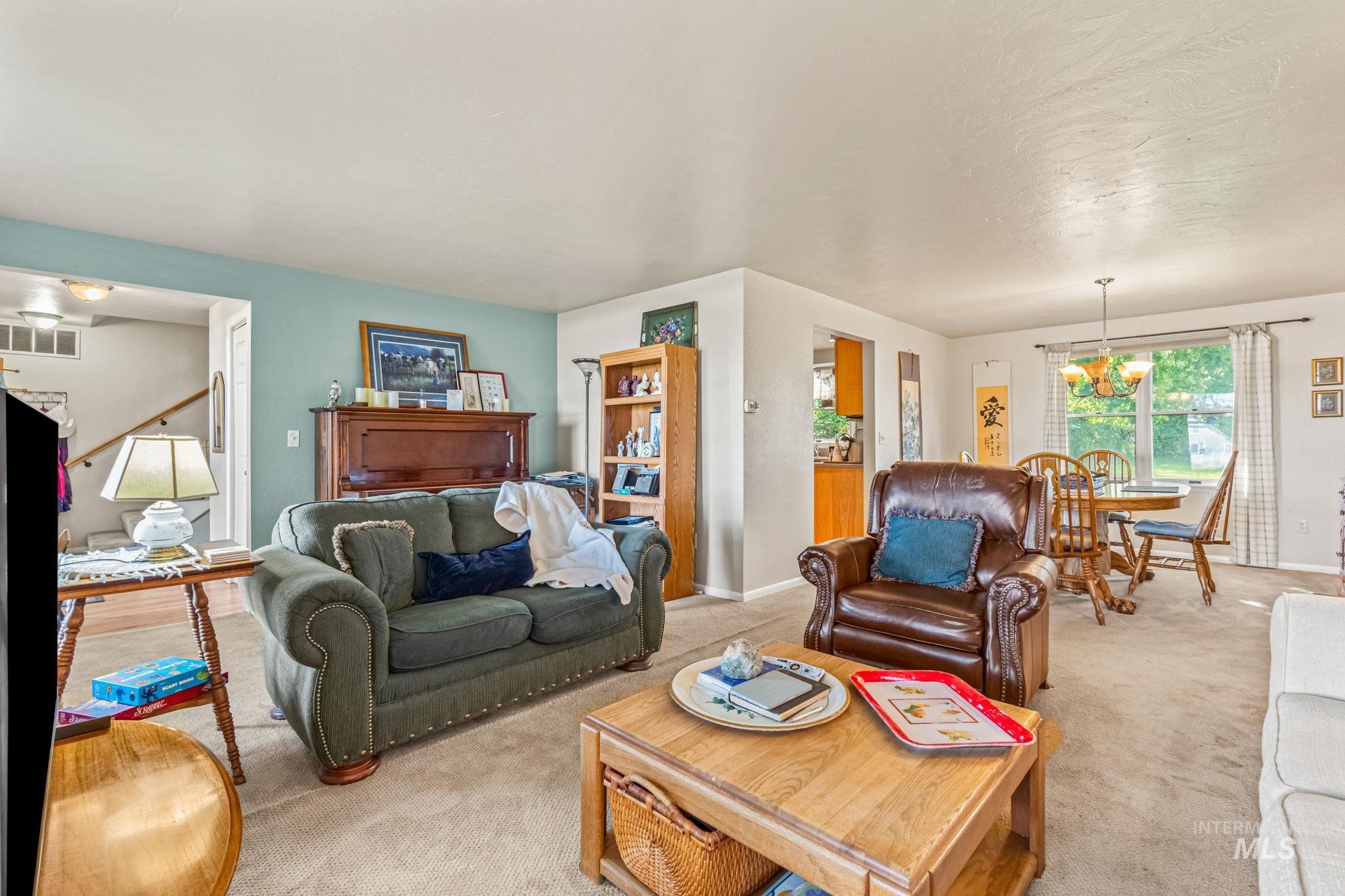 Living area featuring light colored carpet and a chandelier