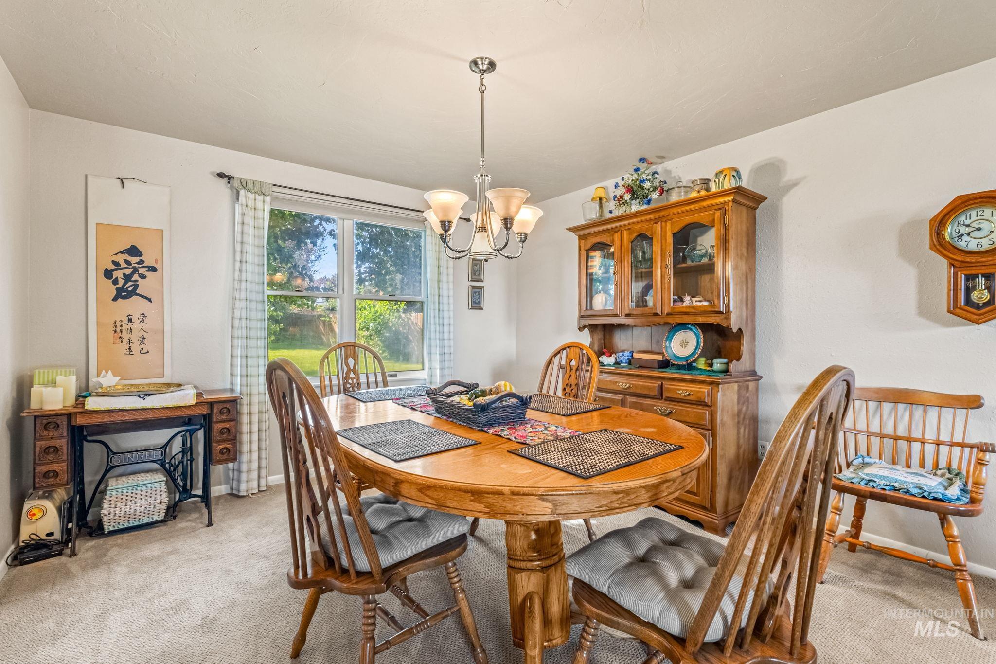Dining space featuring a chandelier and light colored carpet
