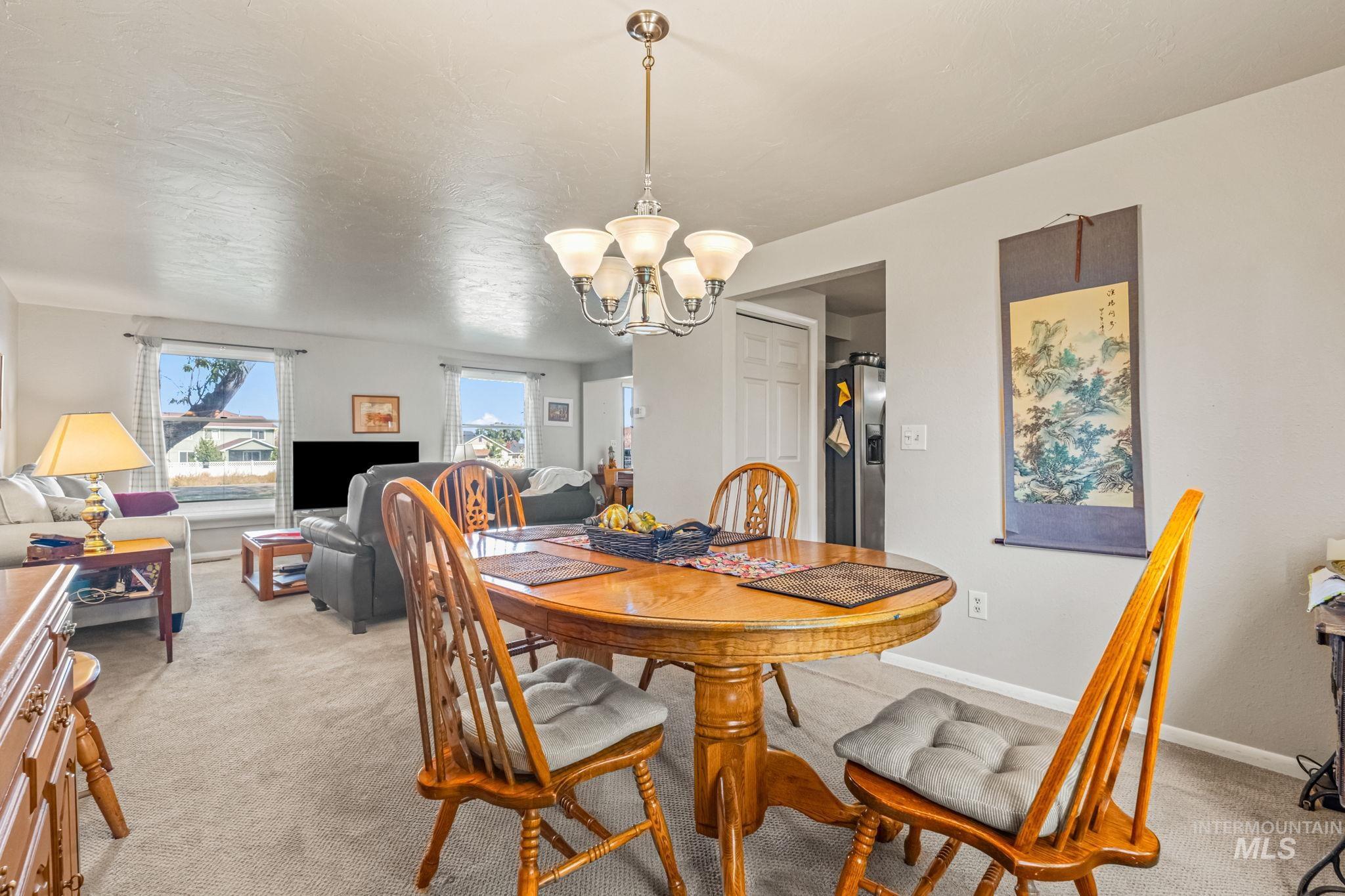 Dining space featuring a chandelier and light colored carpet