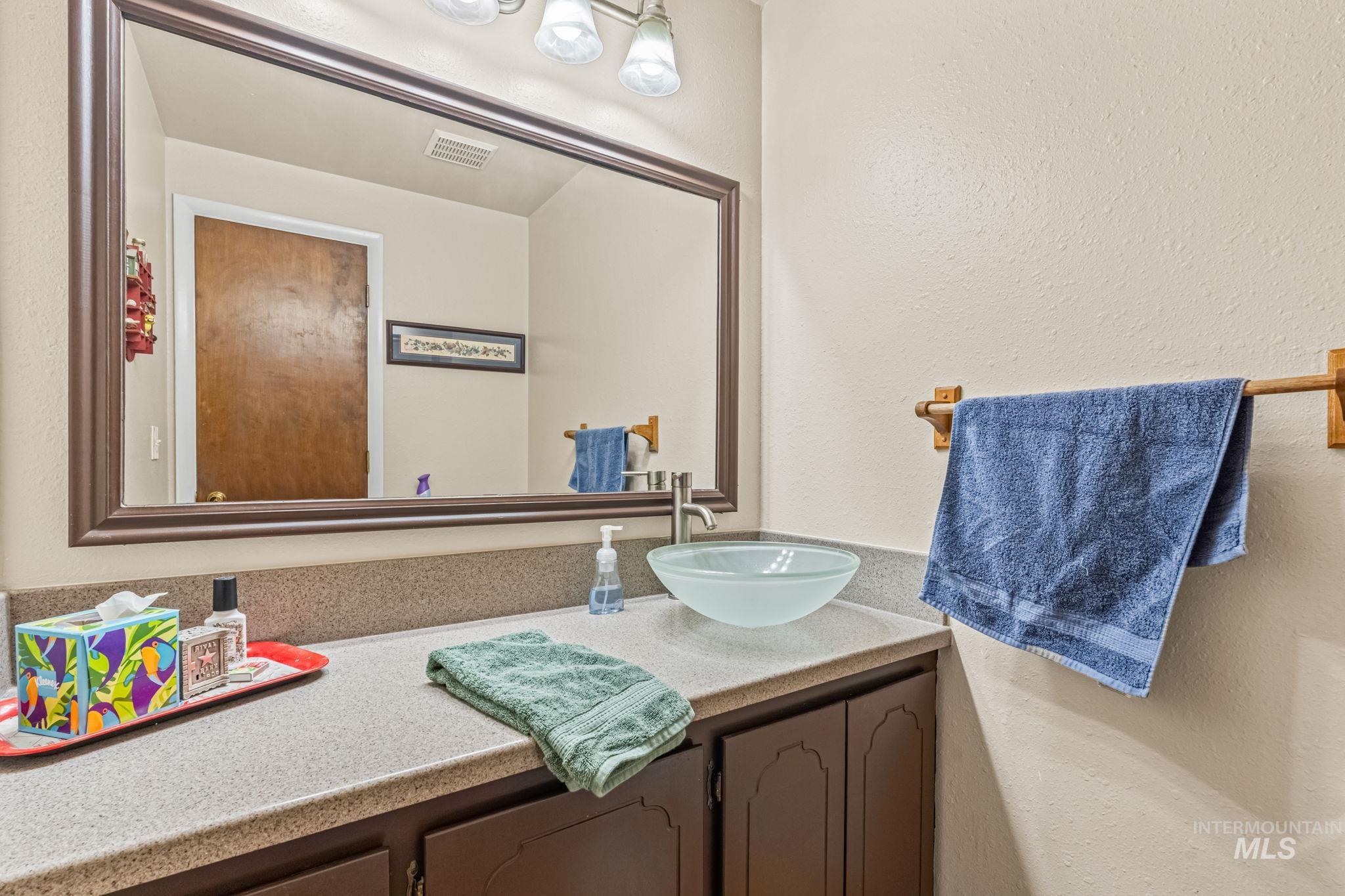 Bathroom featuring vanity and a textured wall