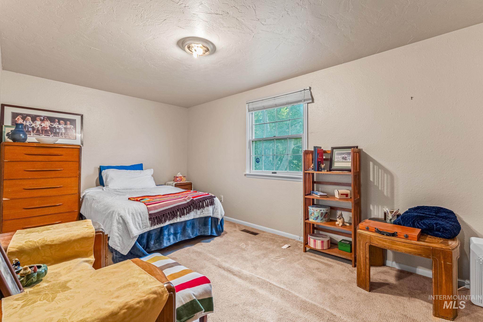 Bedroom featuring carpet flooring and a textured ceiling