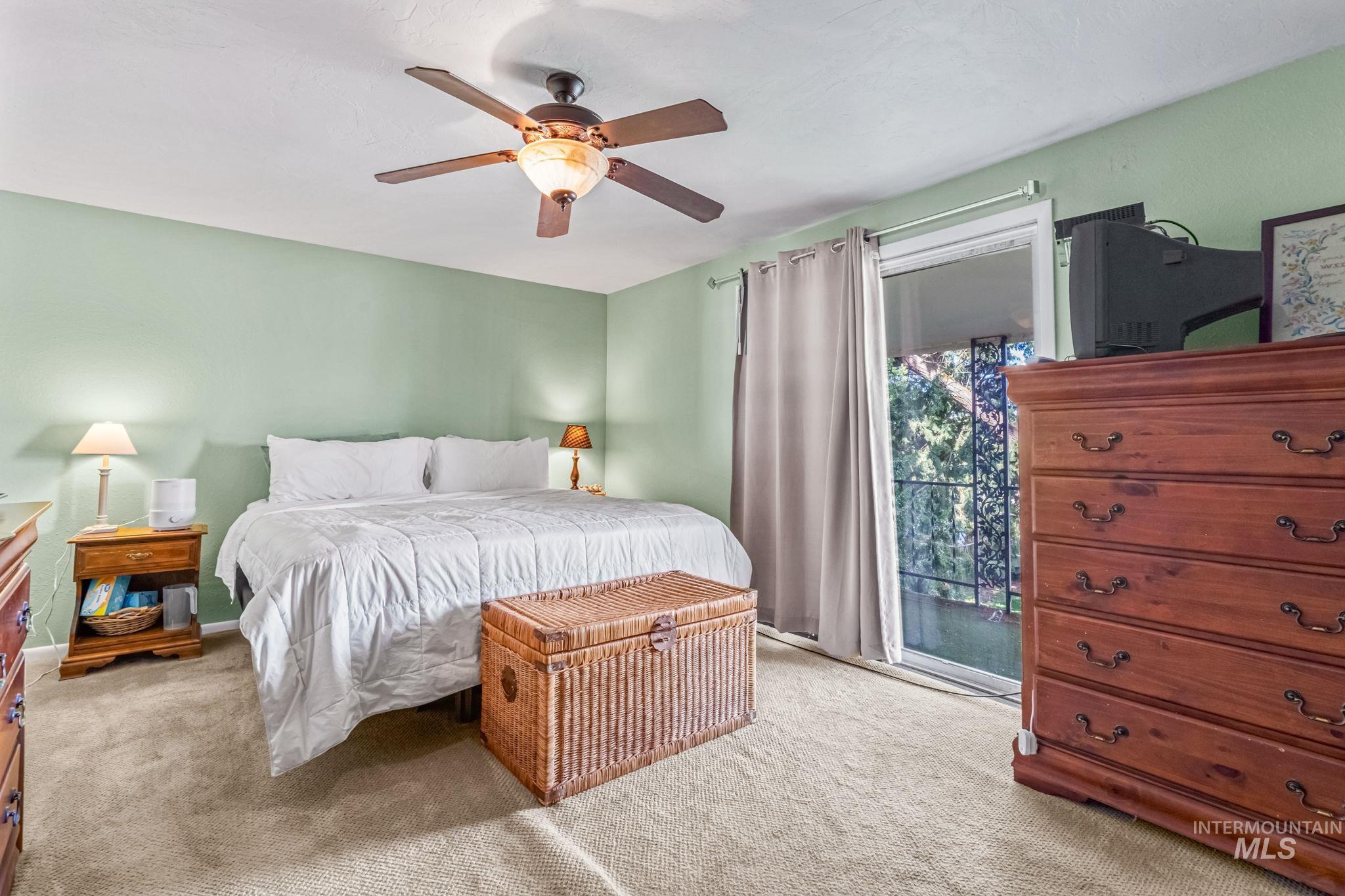 Carpeted bedroom featuring access to exterior and ceiling fan