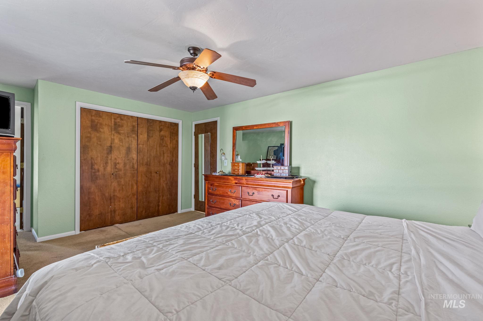 Bedroom featuring a closet, a ceiling fan, and carpet floors
