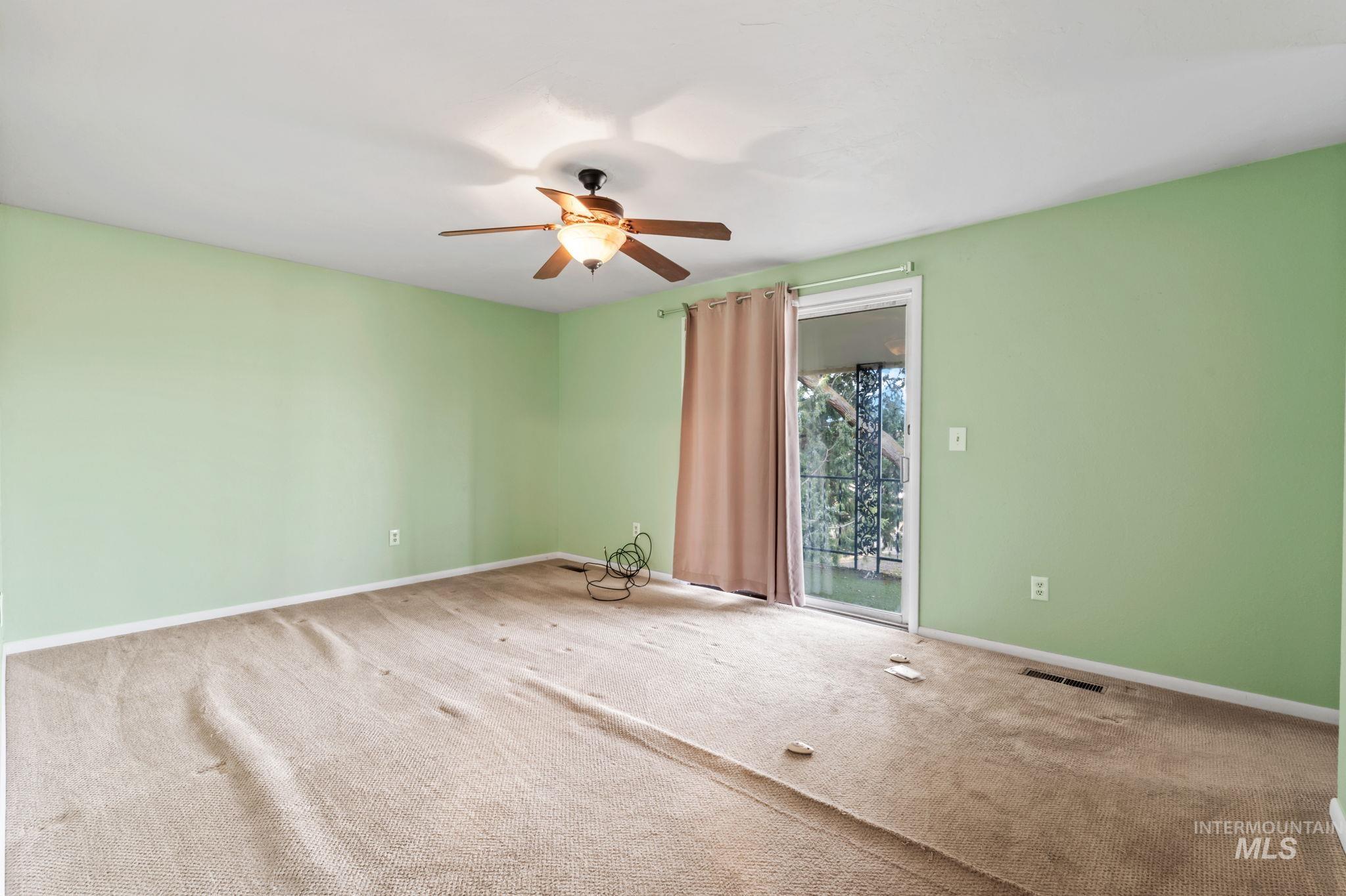Carpeted empty room with baseboards and ceiling fan