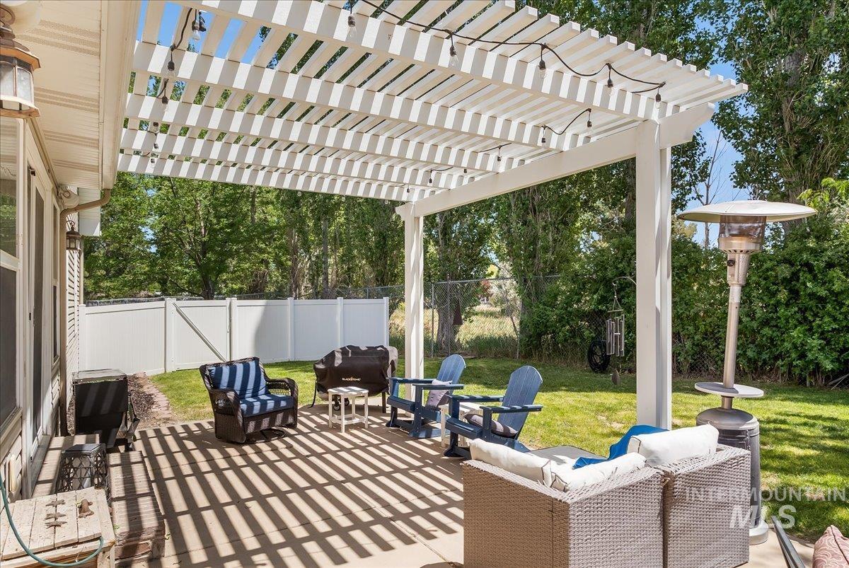 Fenced backyard with an outdoor living space, a pergola, and a patio