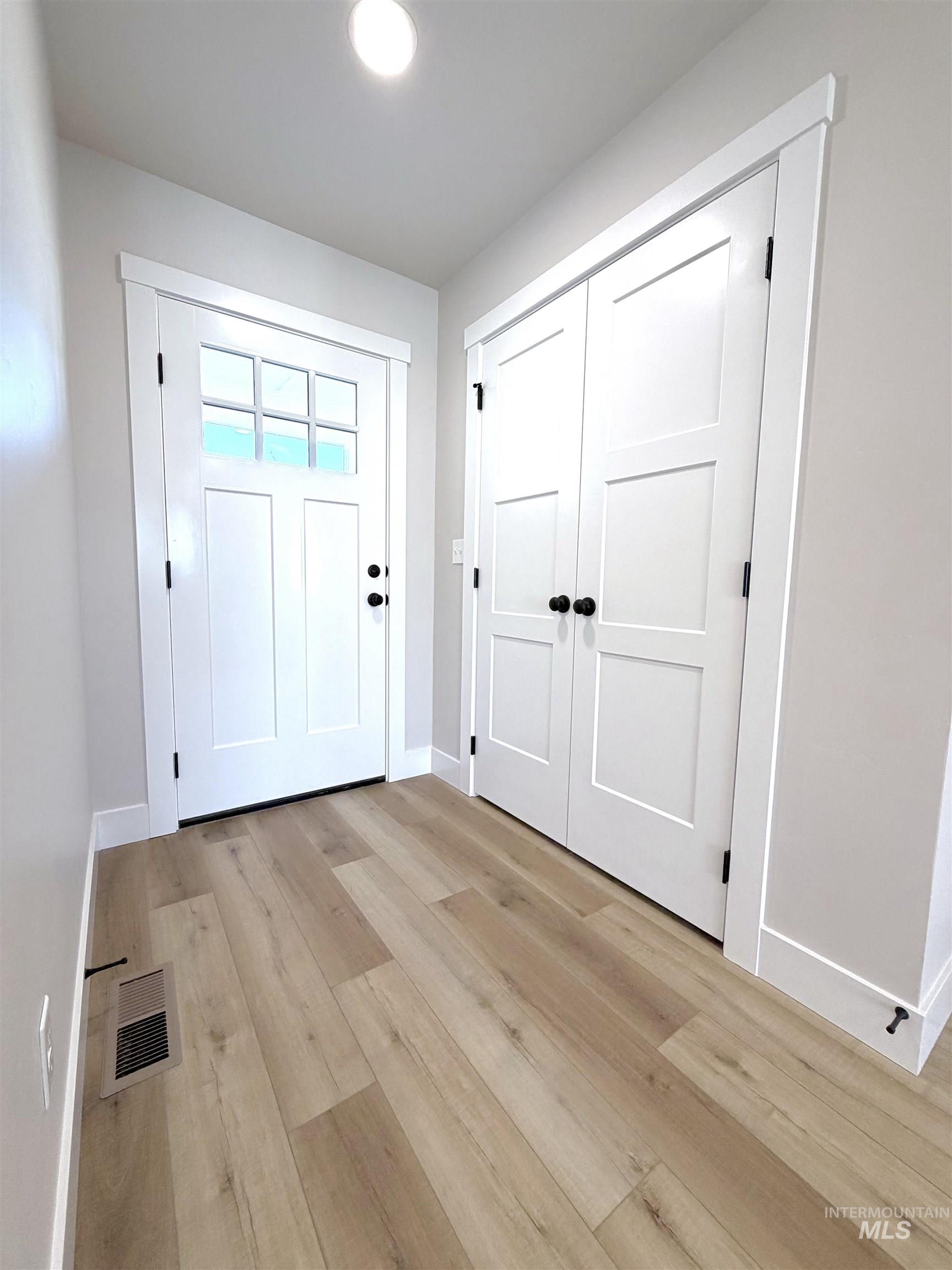 Entrance foyer with light wood-style floors and baseboards