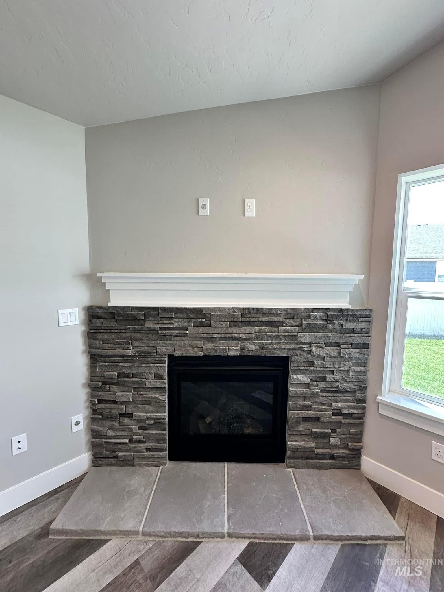 Detailed view of wood finished floors and a fireplace