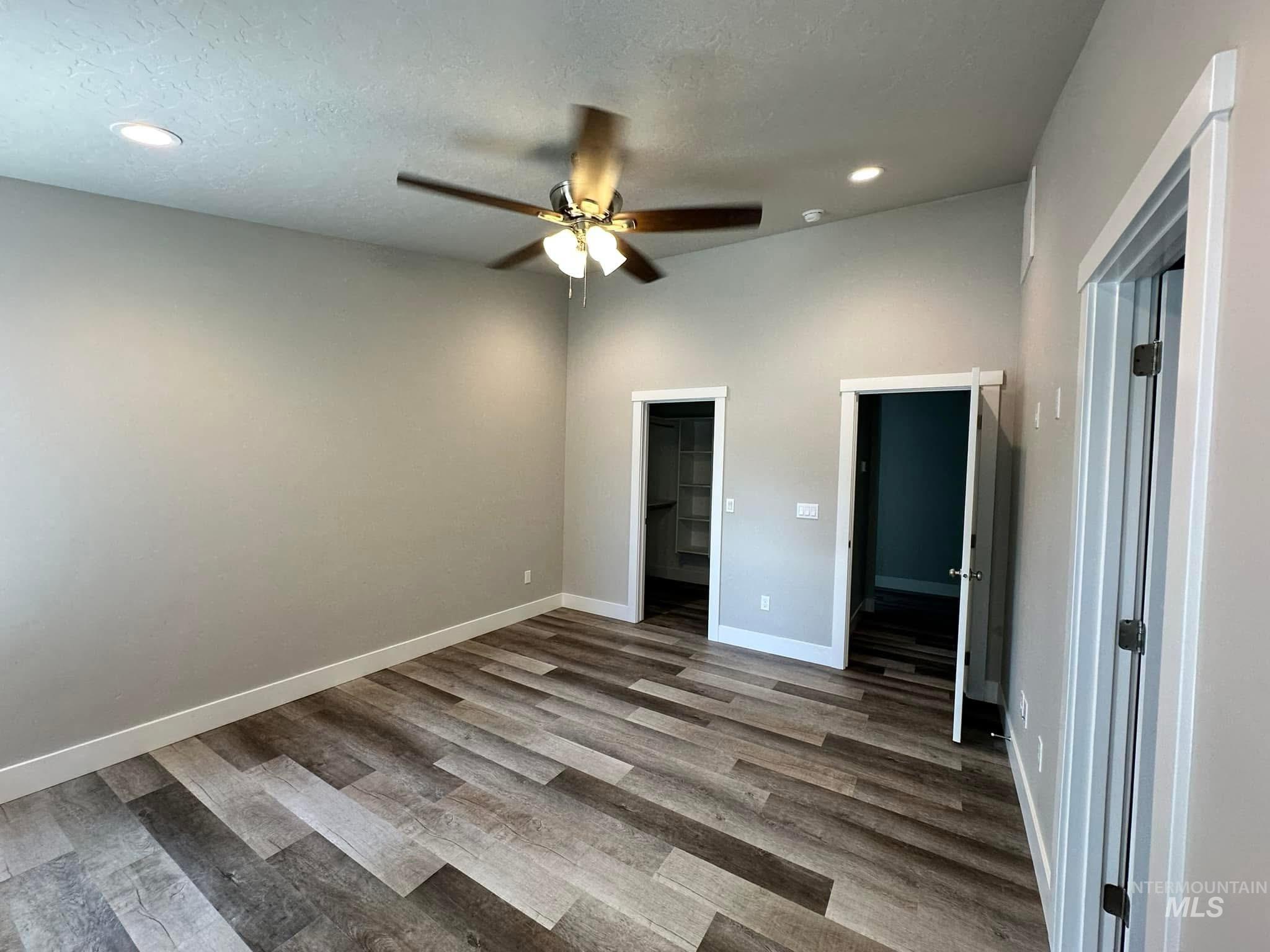Unfurnished bedroom with light wood-style floors, a spacious closet, ceiling fan, recessed lighting, and a textured ceiling