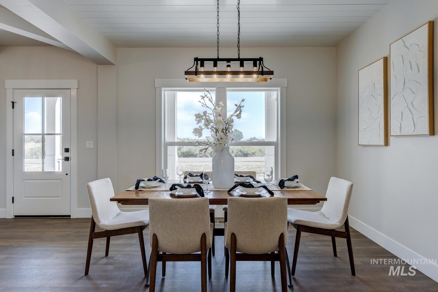 Dining area featuring dark wood-style floors and baseboards