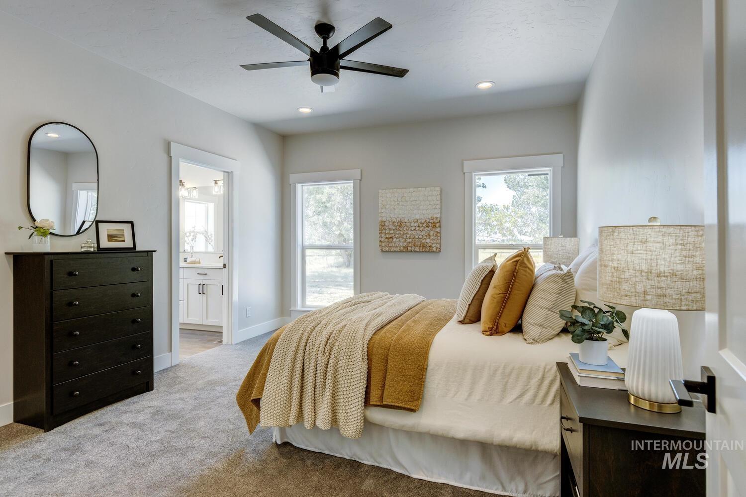 Bedroom with carpet floors, multiple windows, recessed lighting, ensuite bath, and a ceiling fan