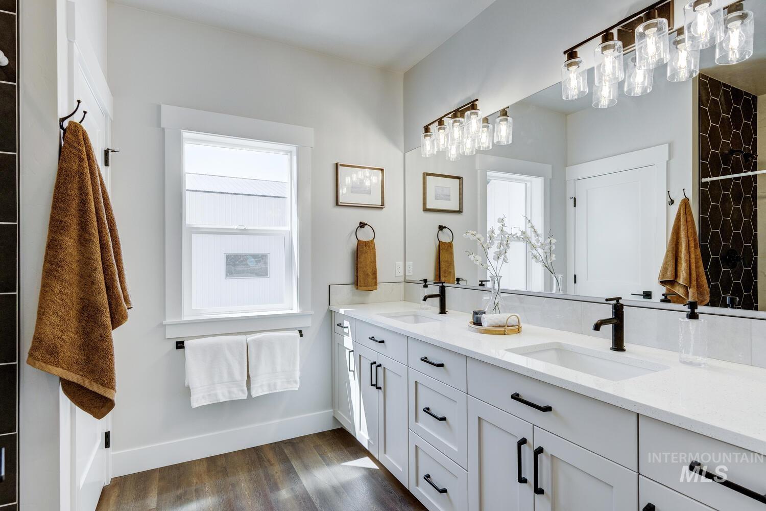 Bathroom with double vanity and wood finished floors