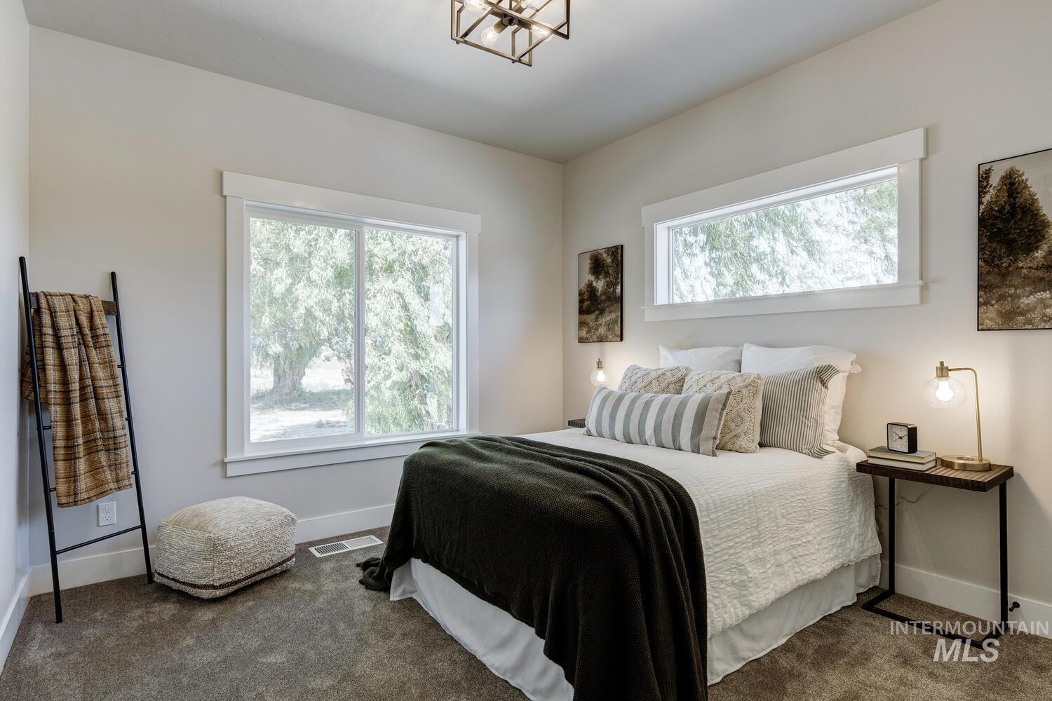 Carpeted bedroom with multiple windows