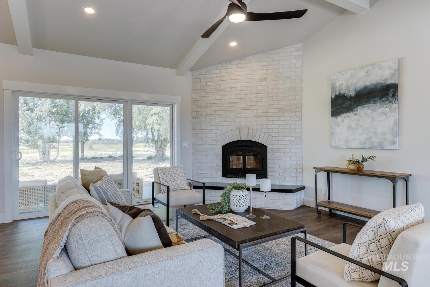 Living area with wood finished floors, a fireplace, and a ceiling fan