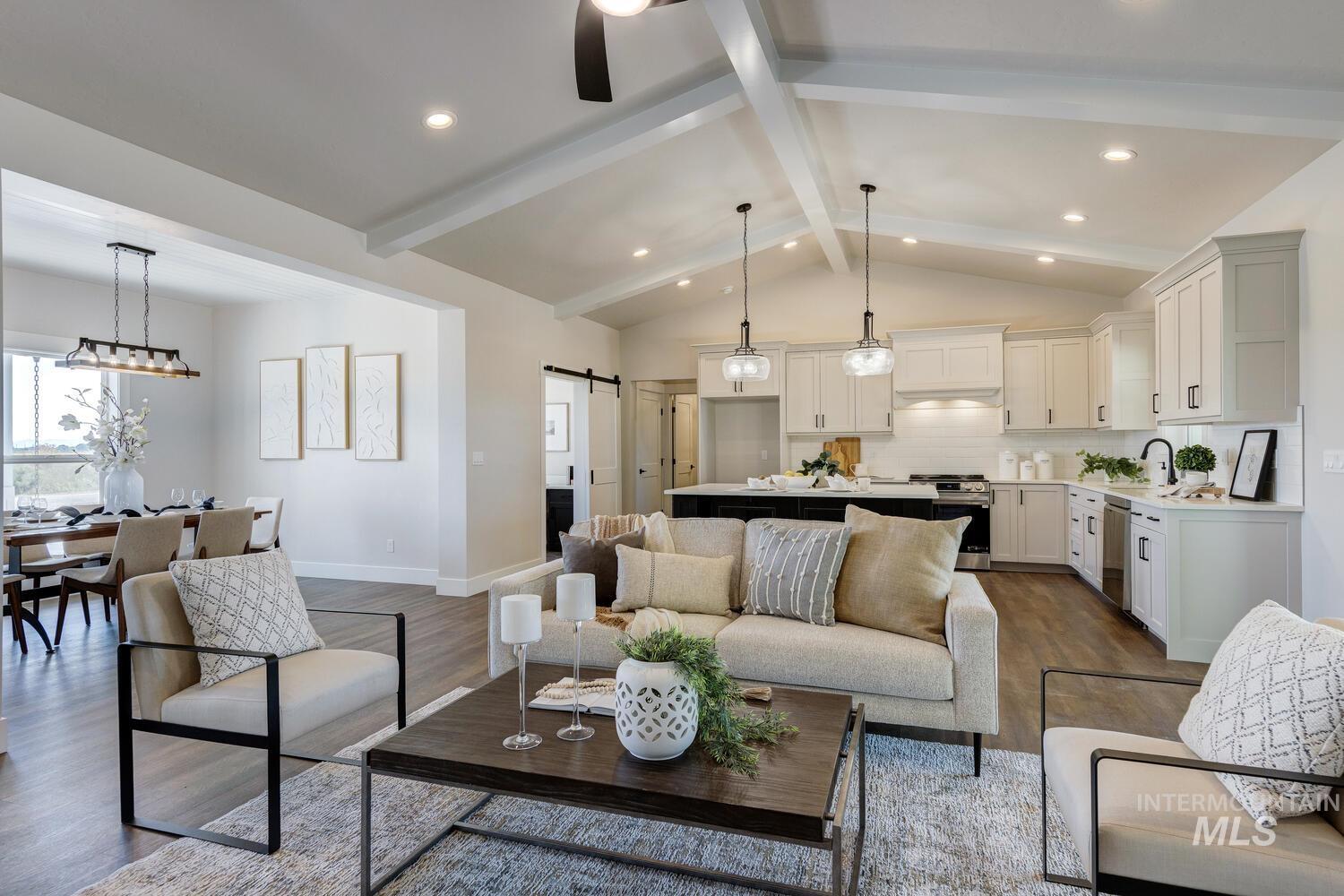 Living room with a barn door, dark wood-style floors, and recessed lighting