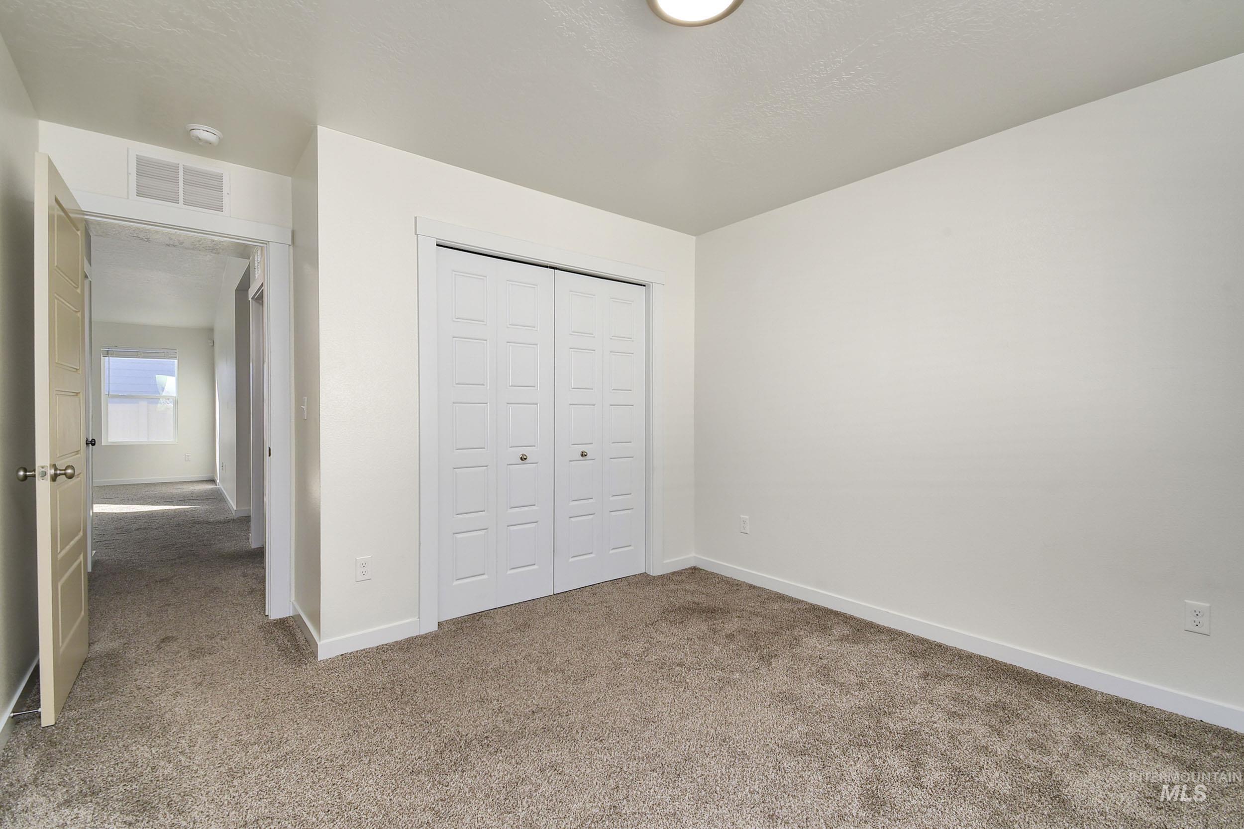 Unfurnished bedroom with carpet floors, a closet, and a textured ceiling