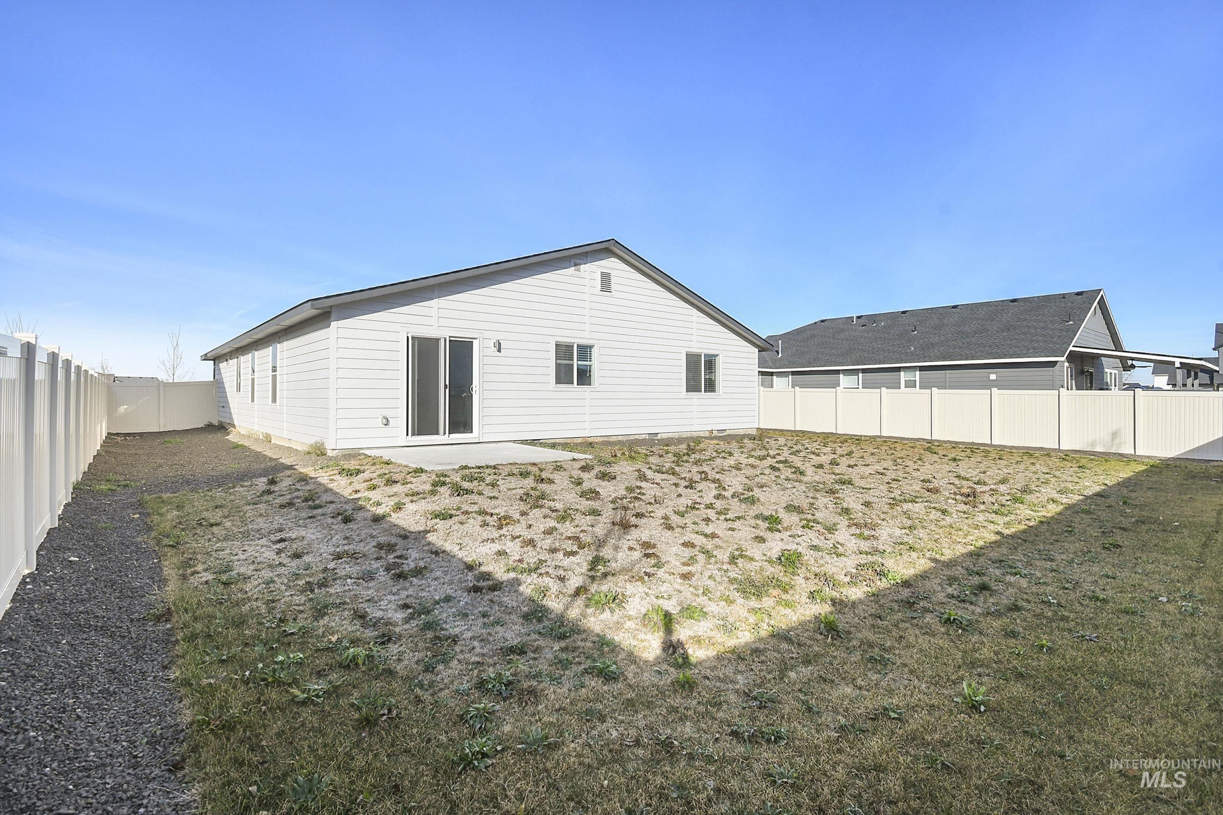 Rear view of property featuring a fenced backyard and a patio