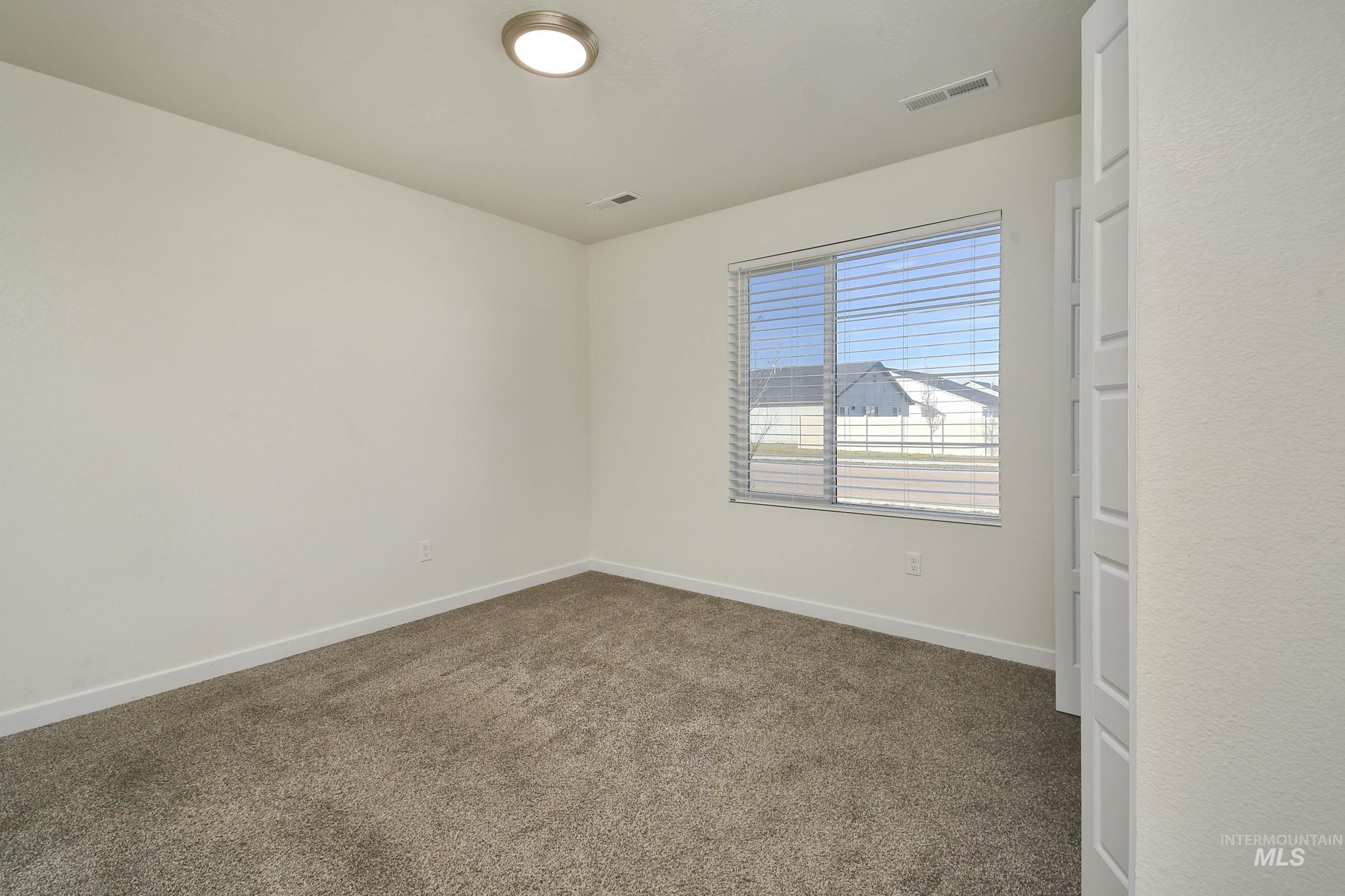Carpeted empty room with baseboards