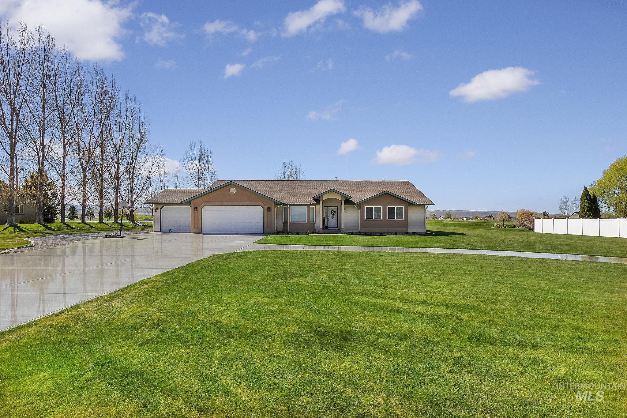 Ranch-style home featuring concrete driveway and a garage