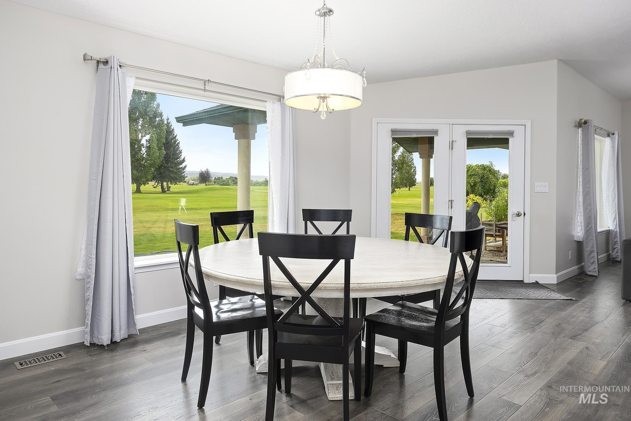 Dining room with french doors, plenty of natural light, and dark wood finished floors