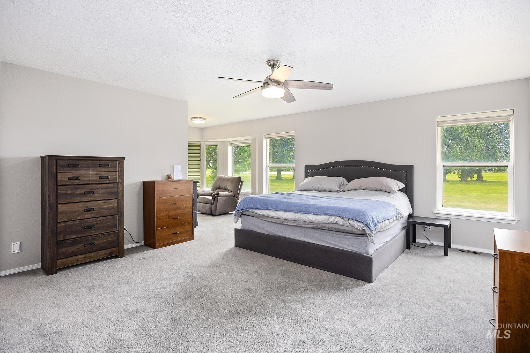 Bedroom featuring light carpet and ceiling fan