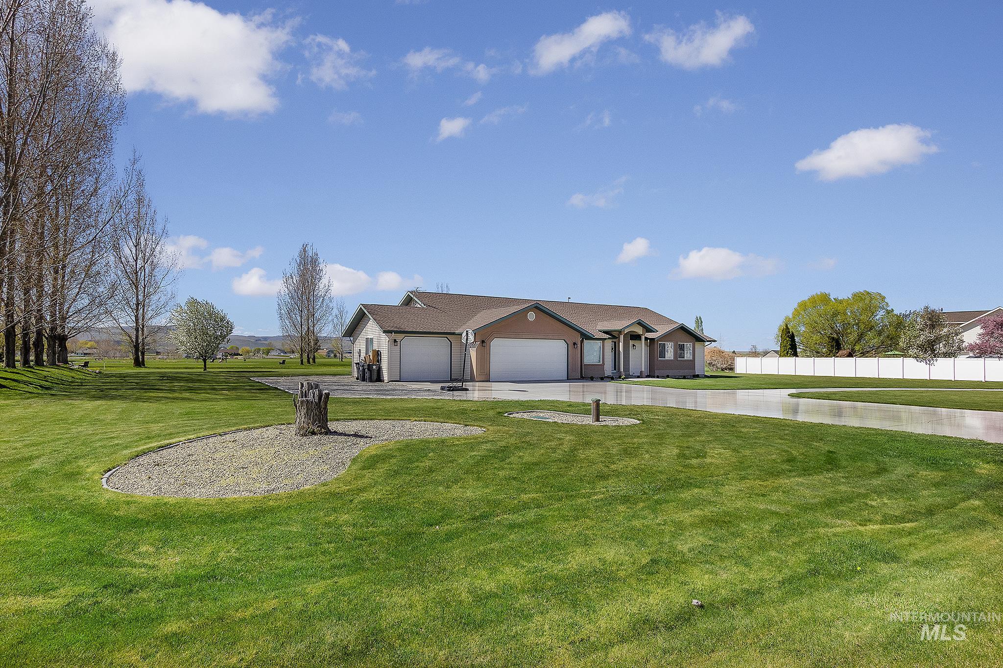 View of front of property featuring a front lawn, a garage, and driveway