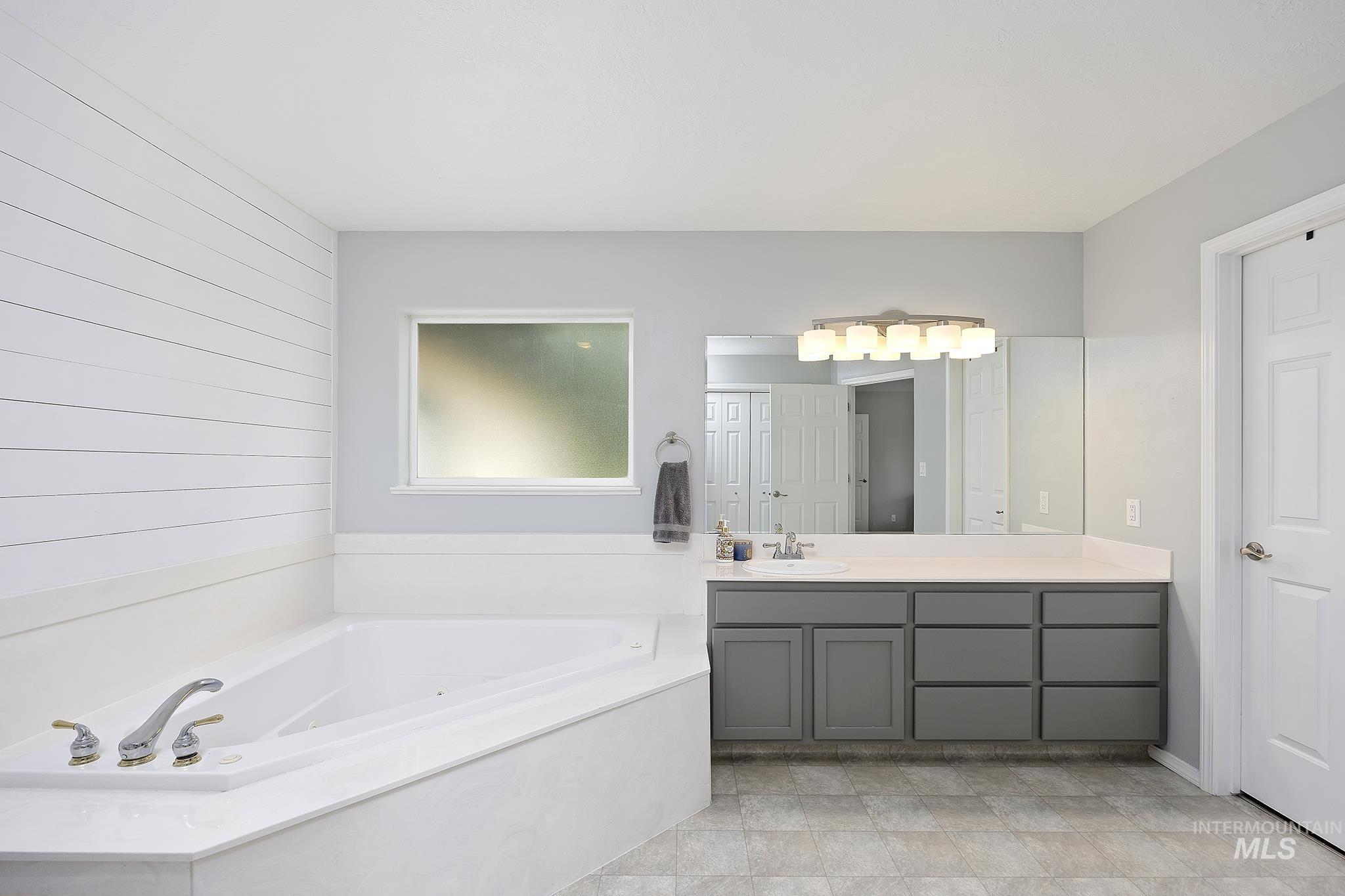 Full bath featuring vanity and a garden tub