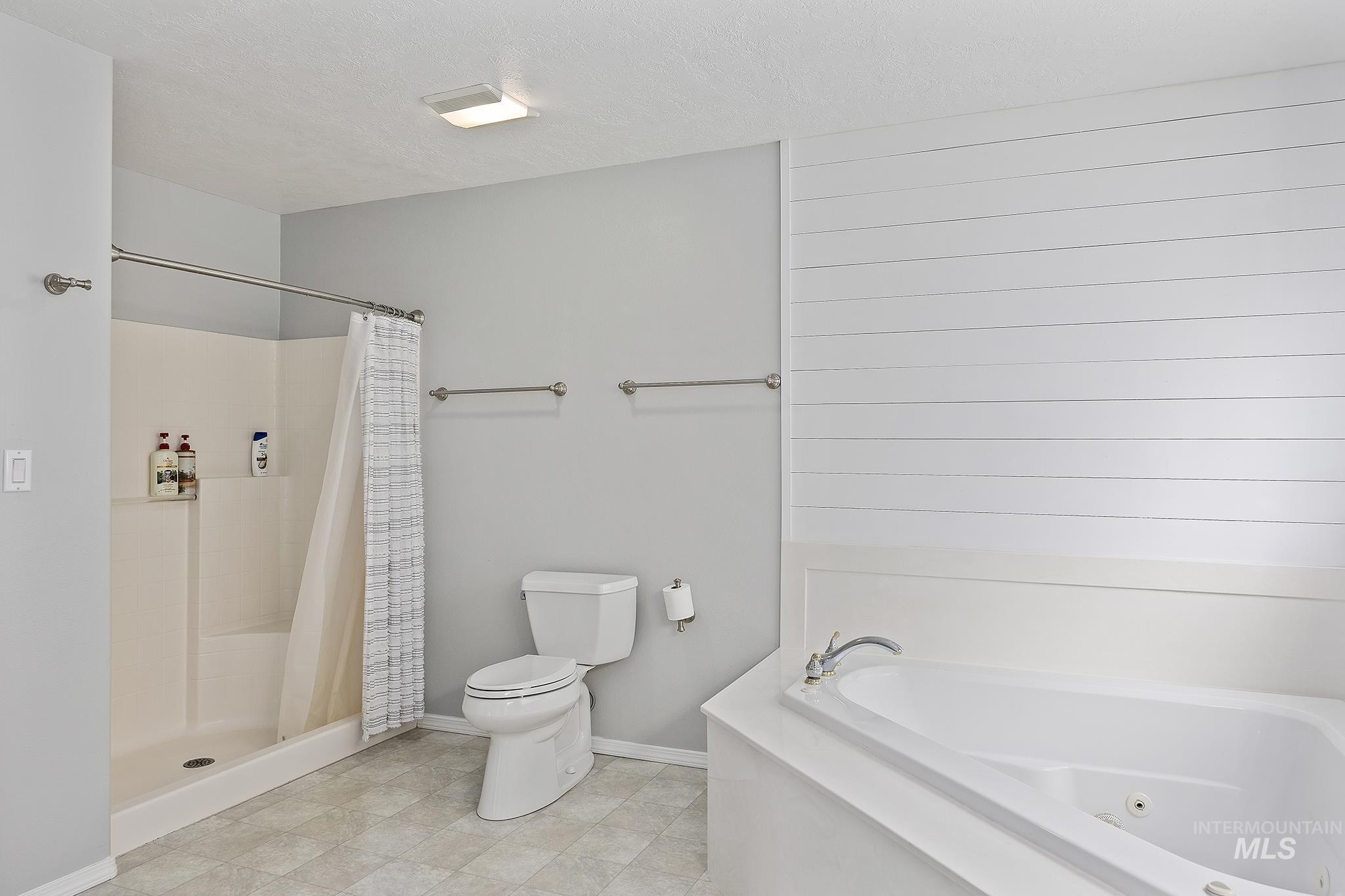 Bathroom with a stall shower and a whirlpool tub