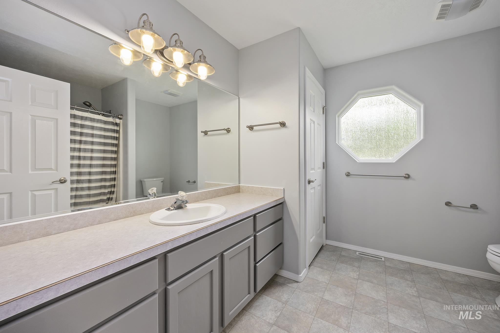Bathroom featuring a shower with curtain, vanity, and a closet