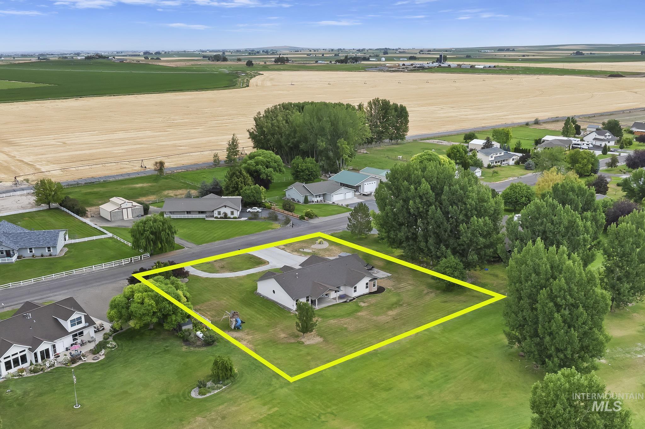 View of rural area featuring property parcel outlined and nearby suburban area