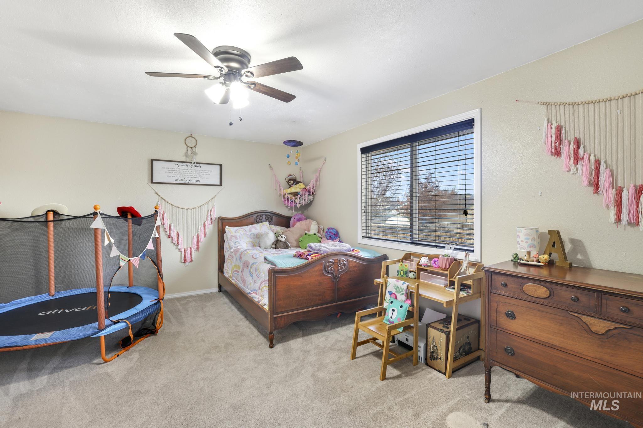 Bedroom featuring light carpet and a ceiling fan