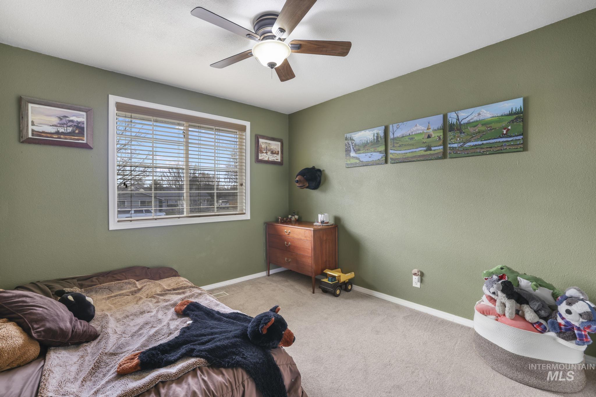 Carpeted bedroom with baseboards and a ceiling fan