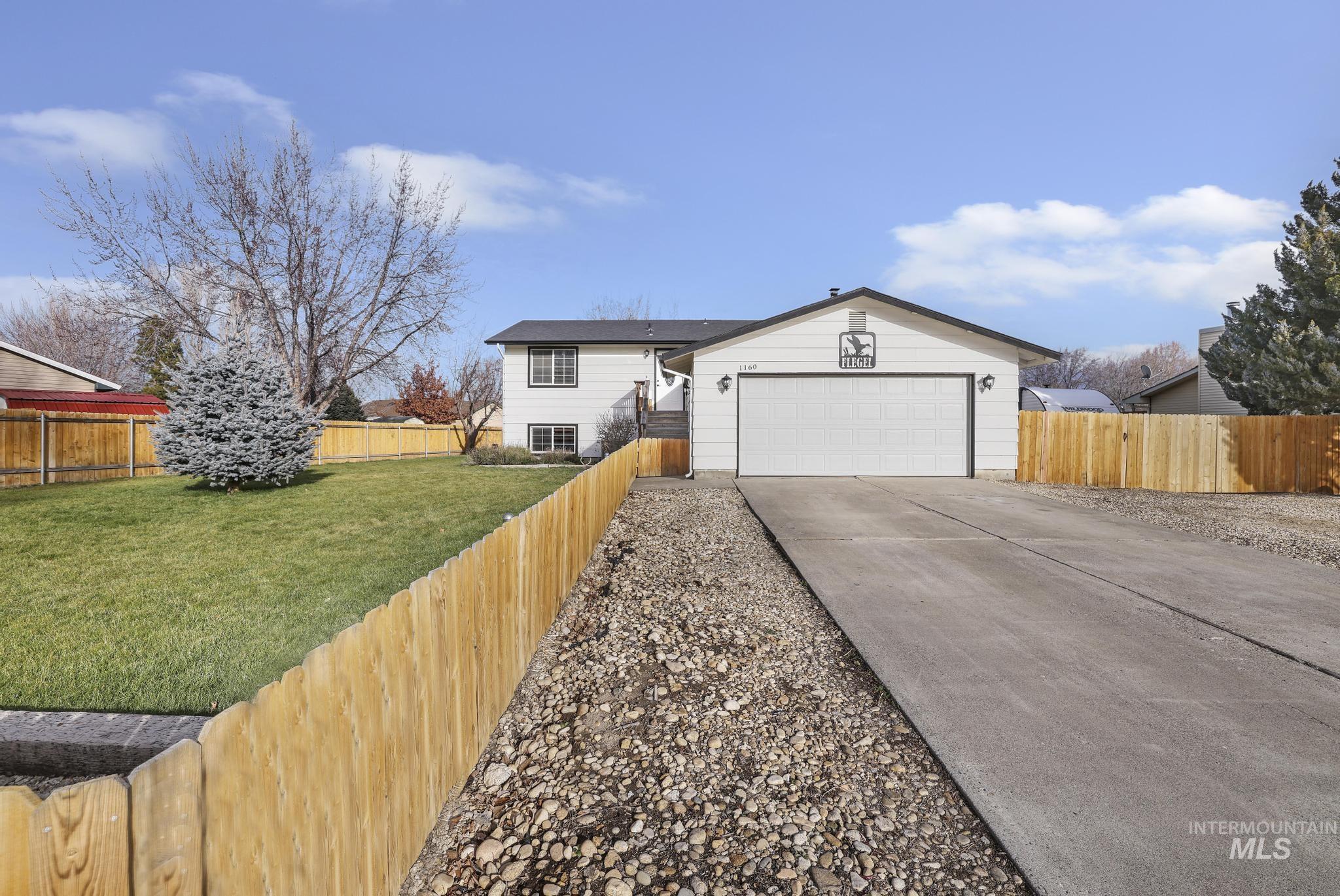 View of front facade with a fenced backyard and concrete driveway