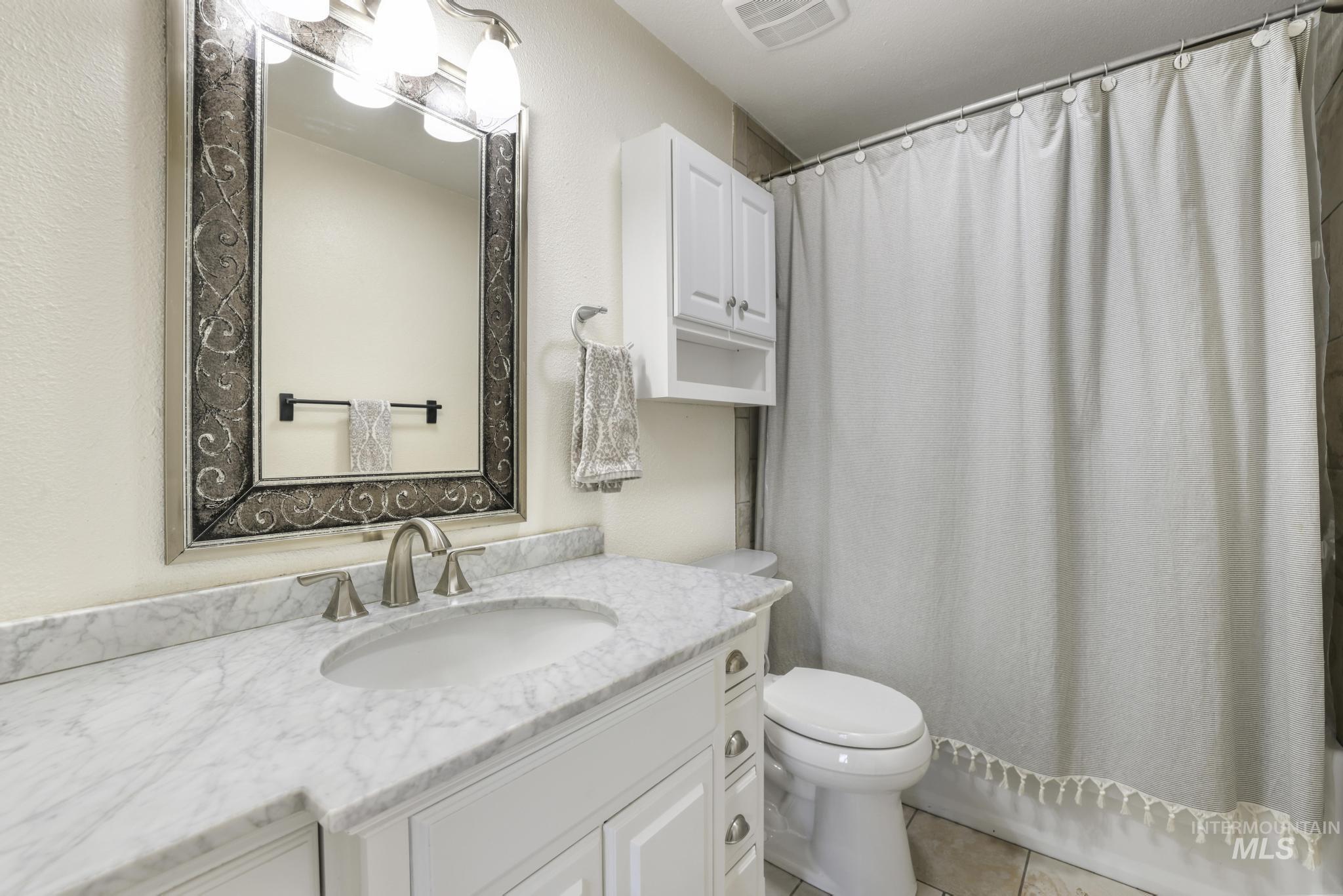 Full bathroom featuring vanity and light tile patterned flooring